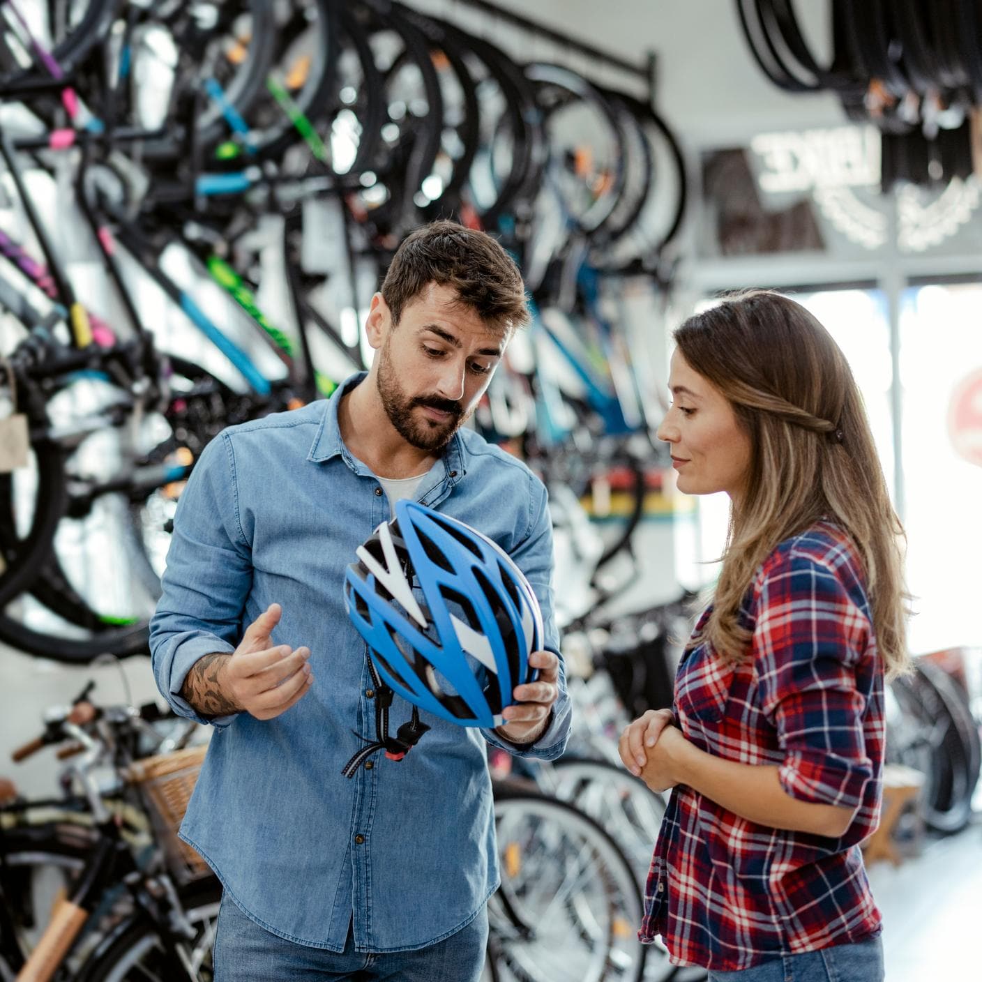 Enhancing Customer Satisfaction - Young couple looking at bicycle helmets in bike shop
