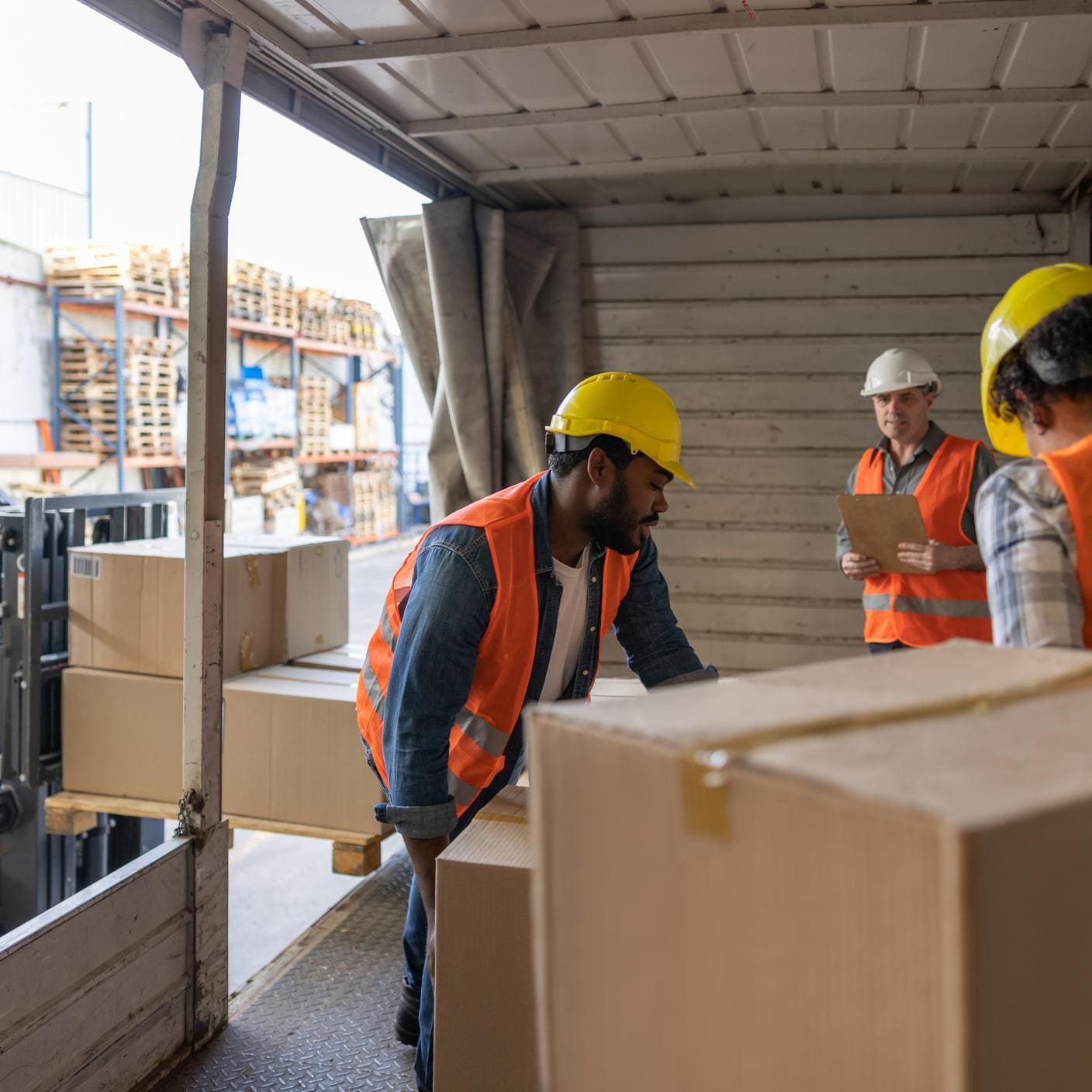 Group of Latin American workers loading a truck while working for a freight transportation company