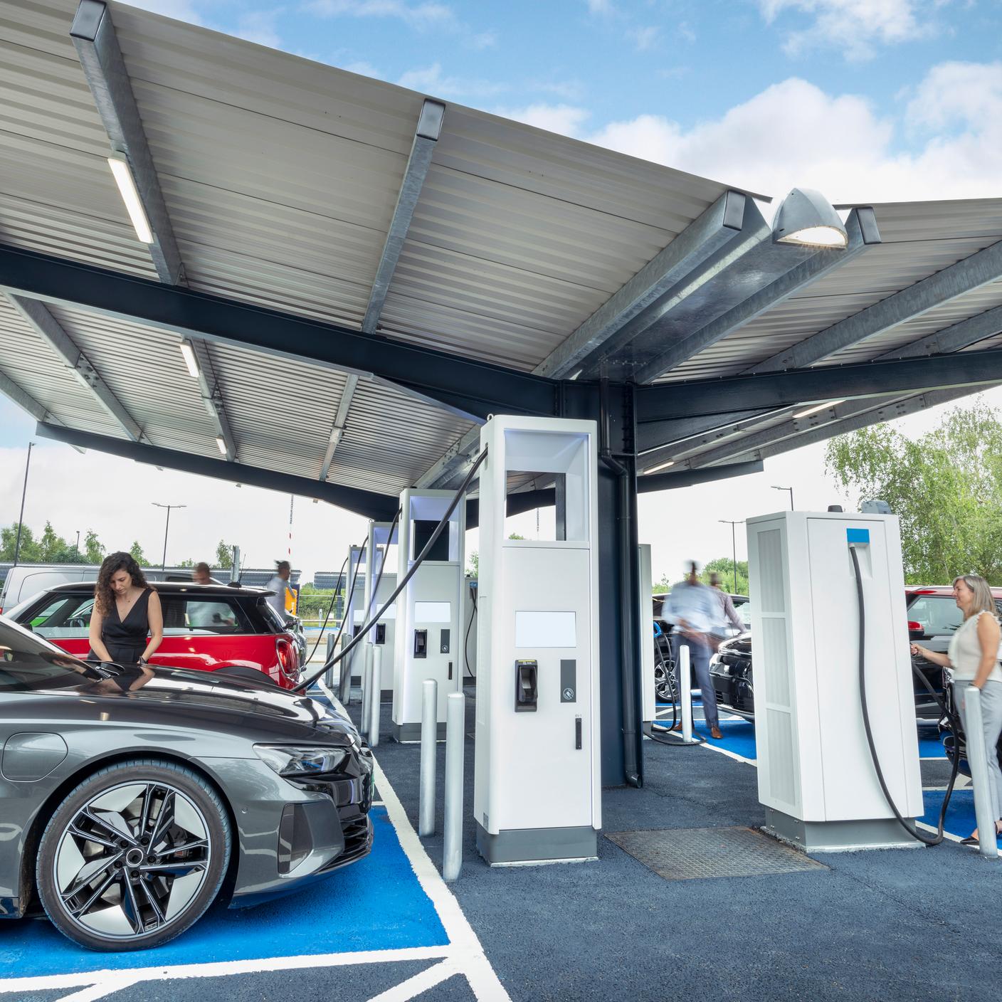 People charging their electric cars at charging station