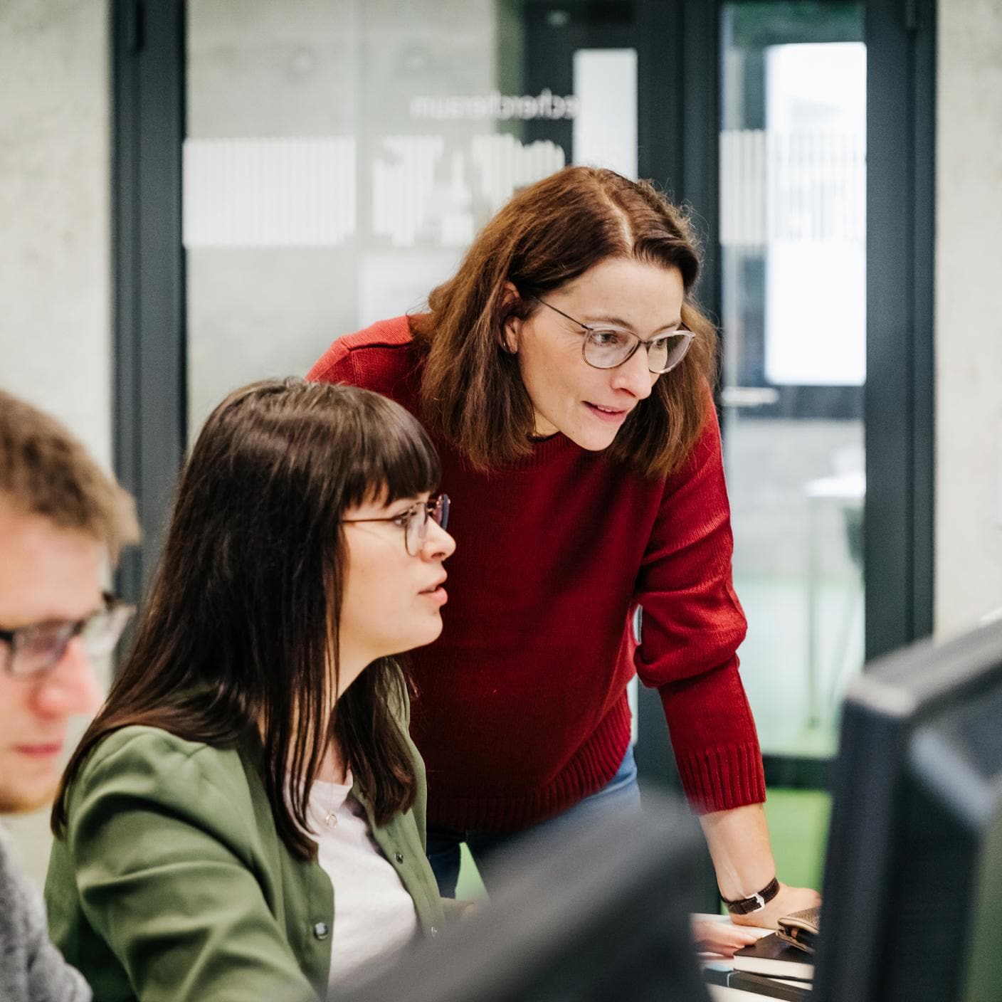 A teacher helping a student with her computer work during a seminar at university.