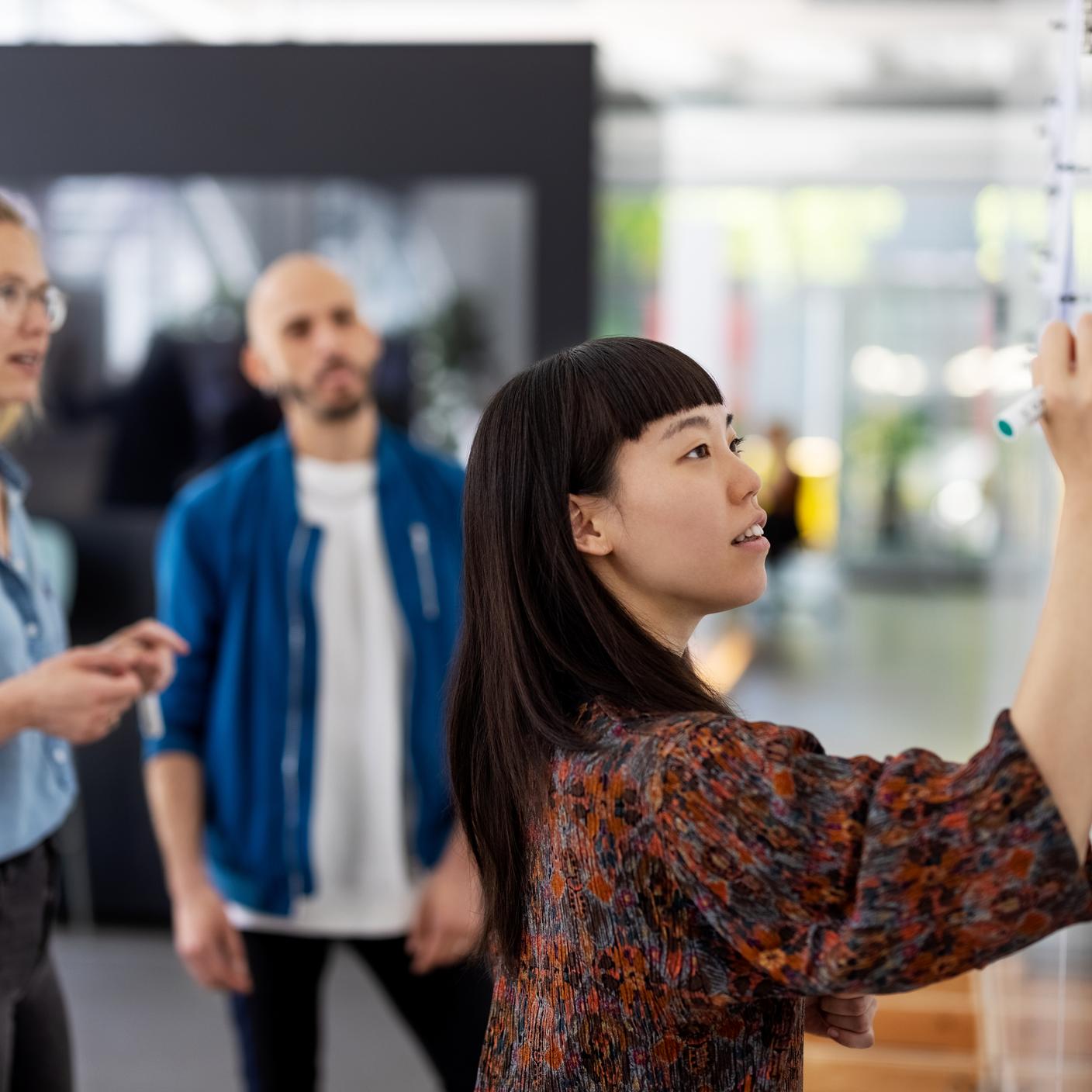 Woman writing on whiteboard in stand up audit session