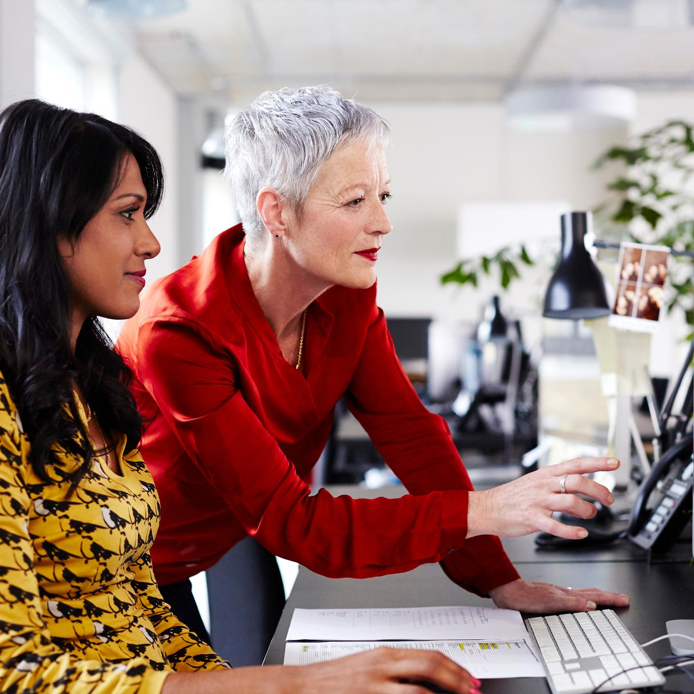 two female workers looking at a monitor screen