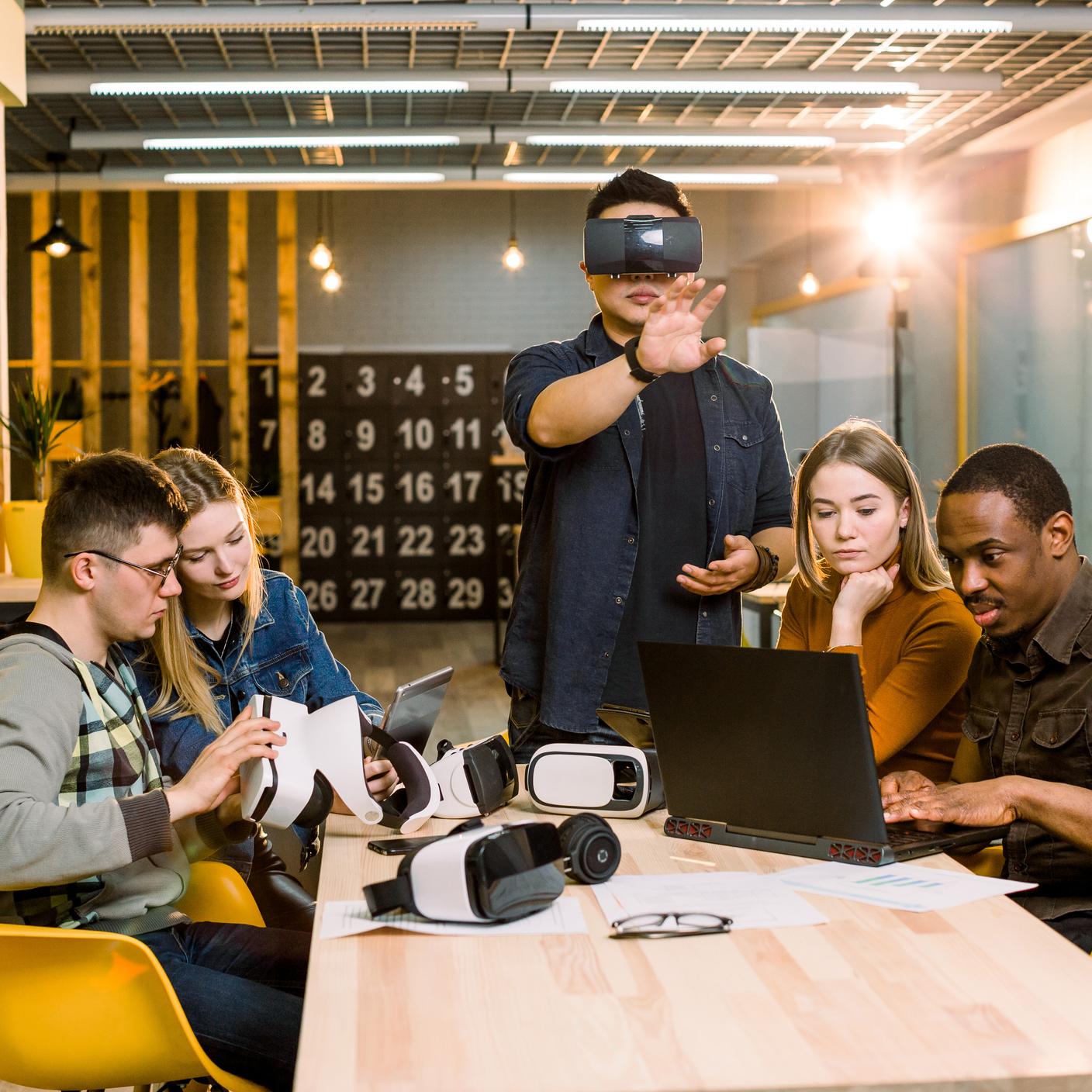 Teamwork trying virtual reality glasses for work in creative office