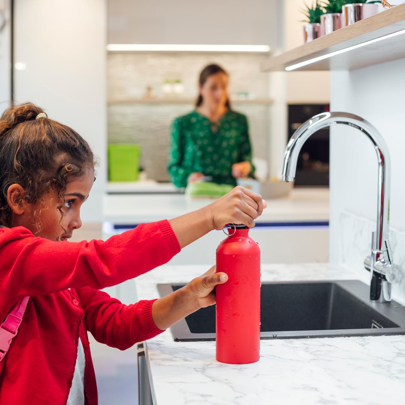 Sustainability in government - school girl filling water bottle