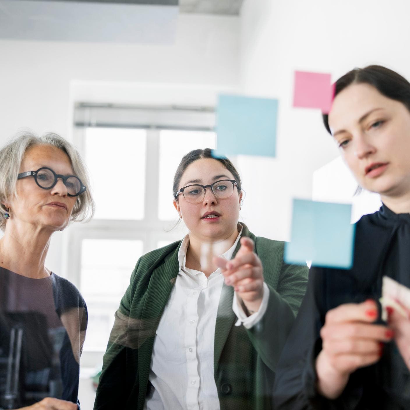 Female professionals going over post-it notes in a meeting