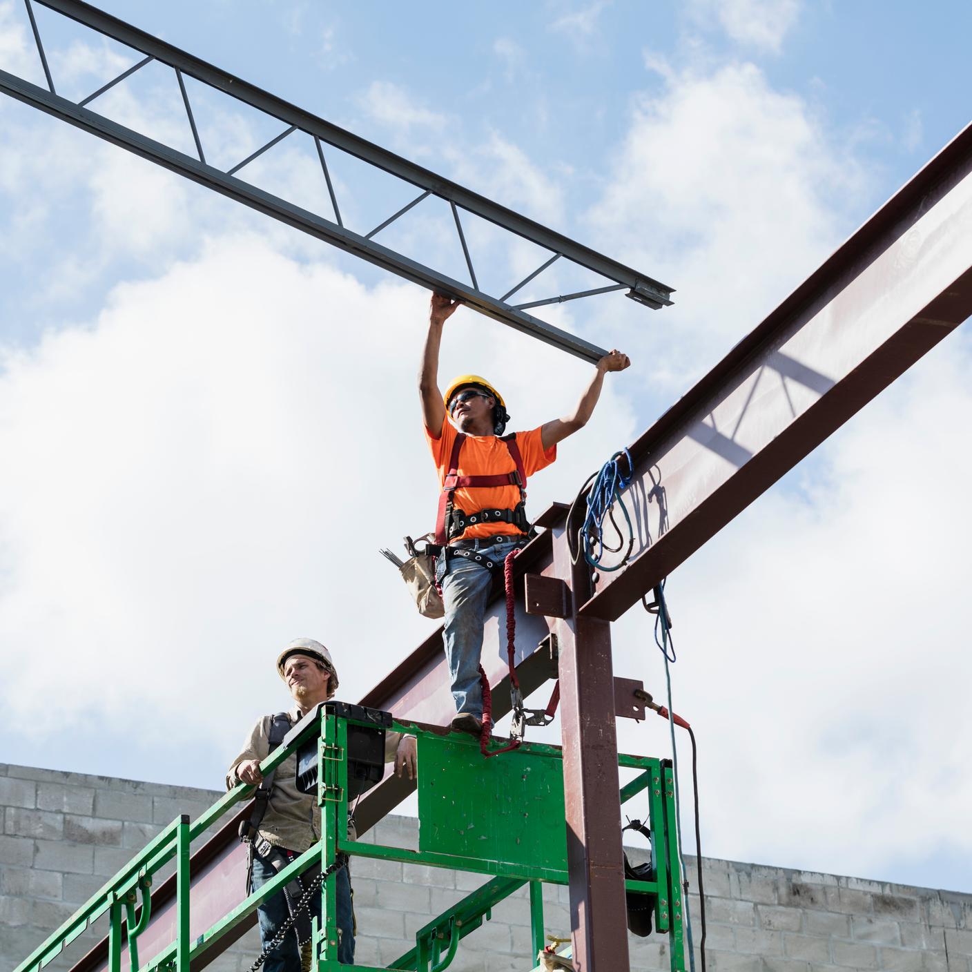 Building and Construction - Two multi-ethnic construction workers on a scissor lift