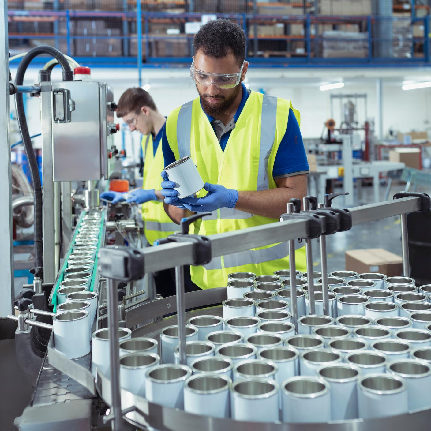 Quality Management - Workers on filling line in oil blending plant