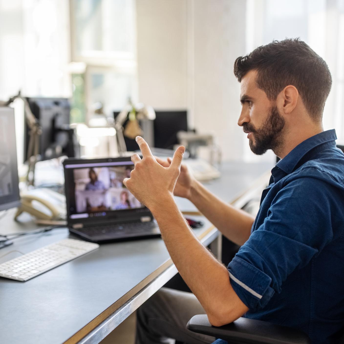 Businessman sitting at his desk having a video conference with colleagues