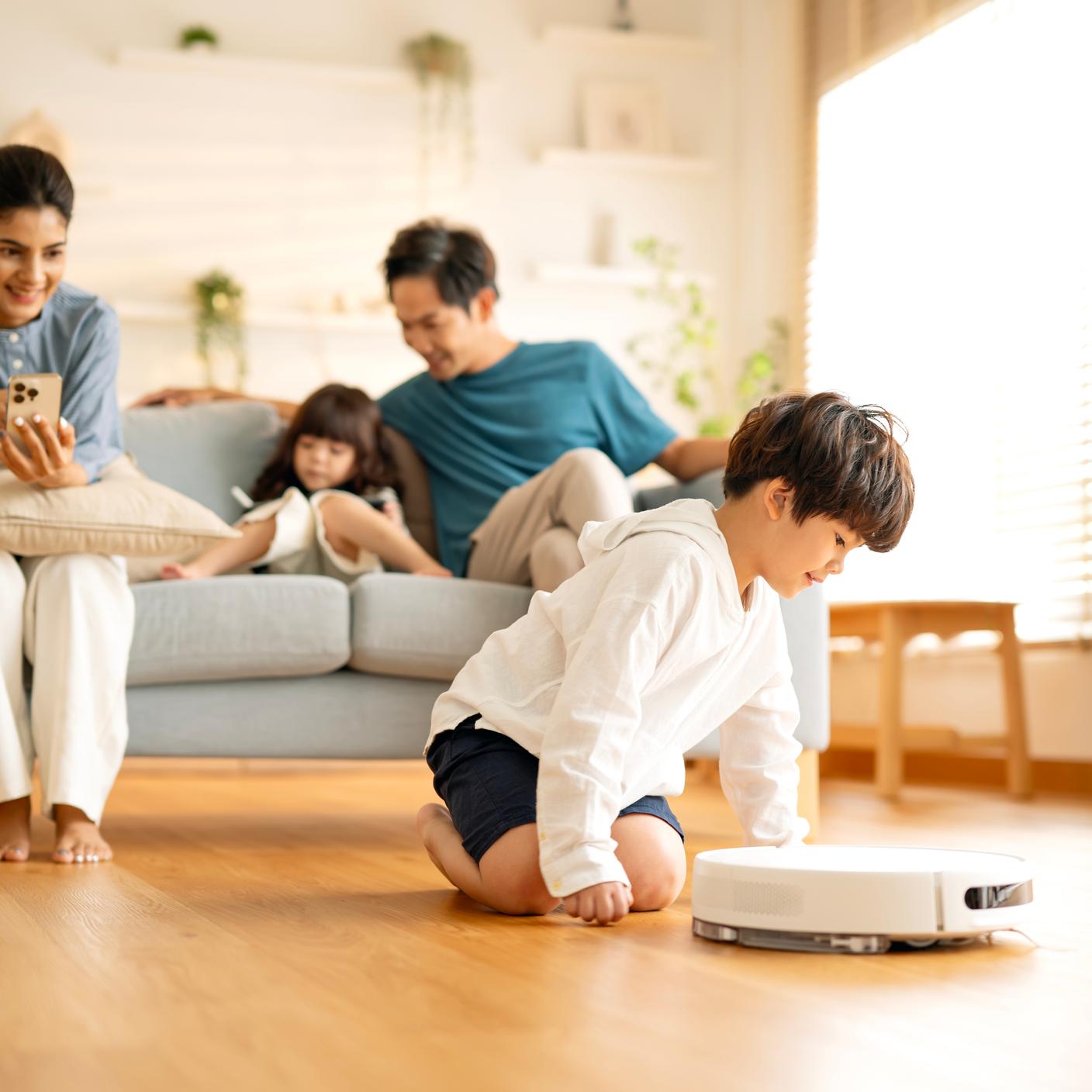 Supporting move to low energy system -  boy crawling following robot vacuum