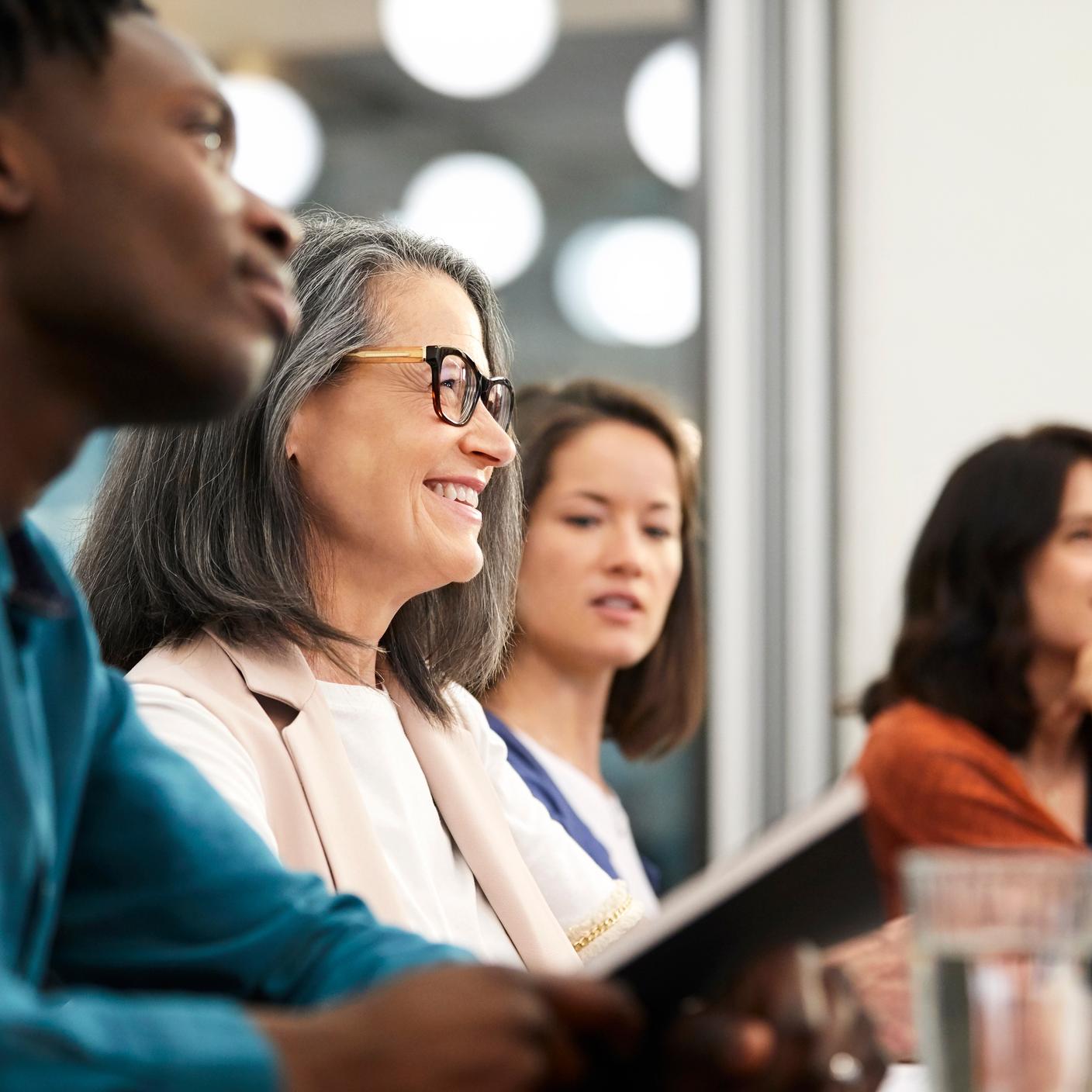 How we work with our clients - Male and female executives are in board room during meeting.