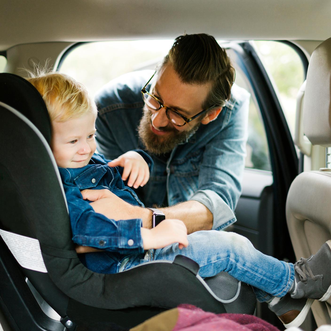 Kitemark - Man putting his son into baby car seat