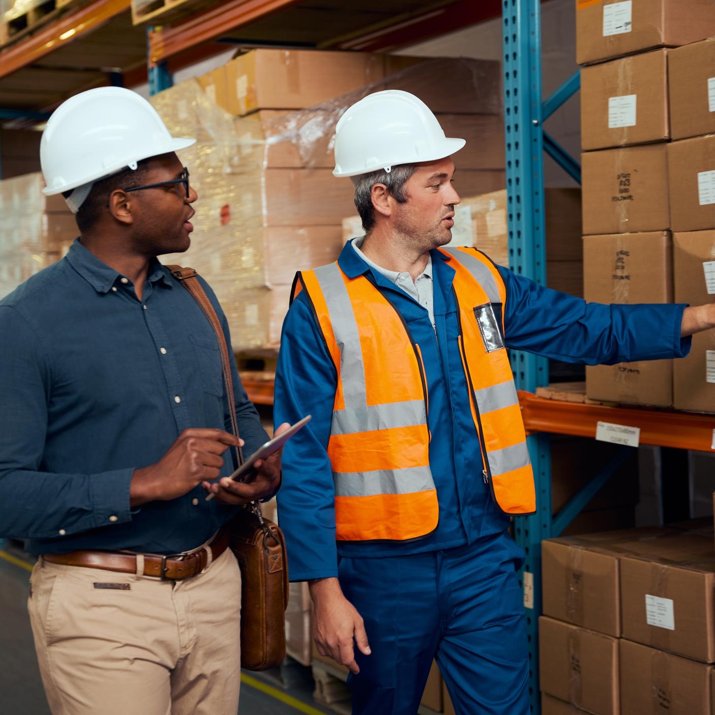 How we work with our clients - Male factory worker showing stock to his inventory using digital tablet