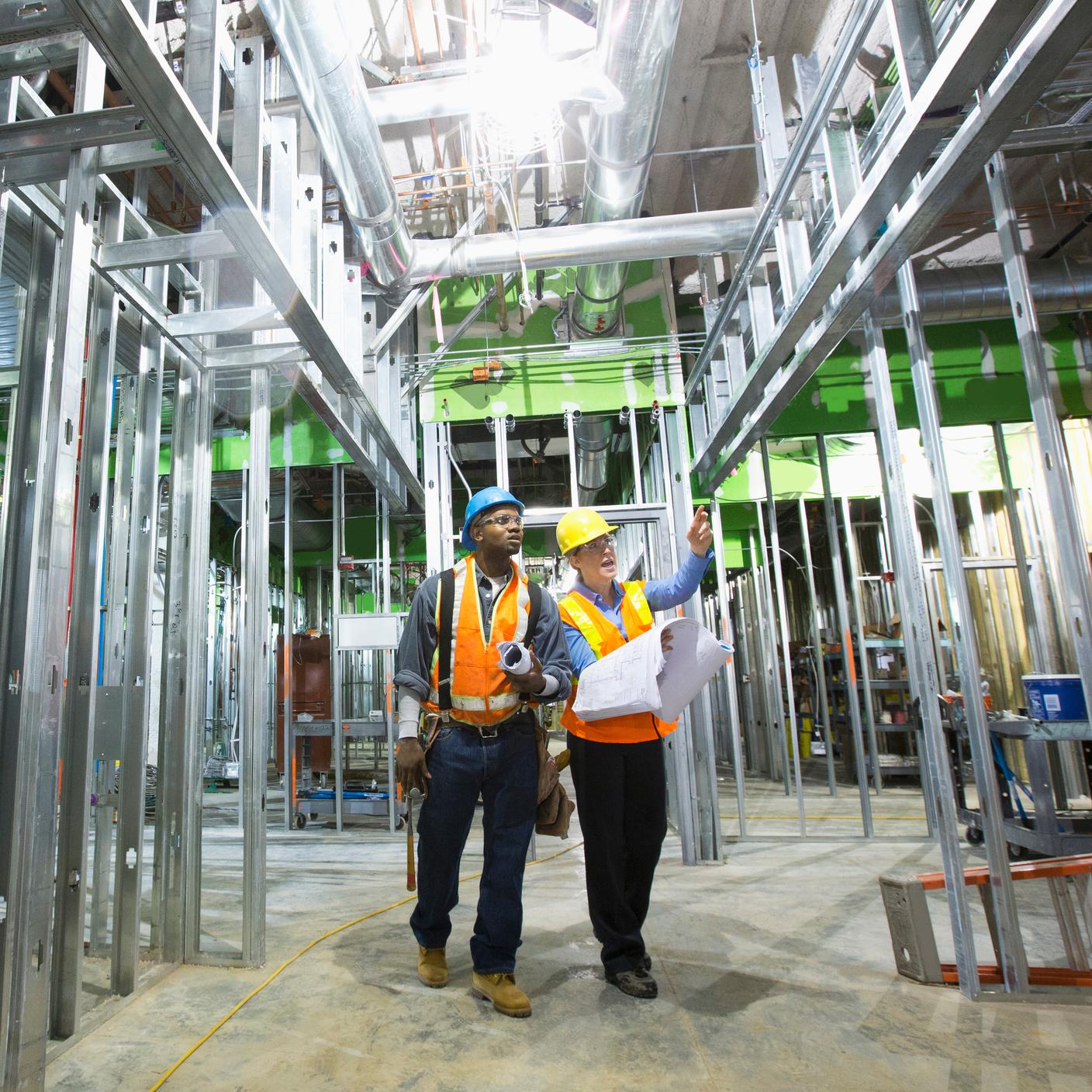 Two workers talking on site.