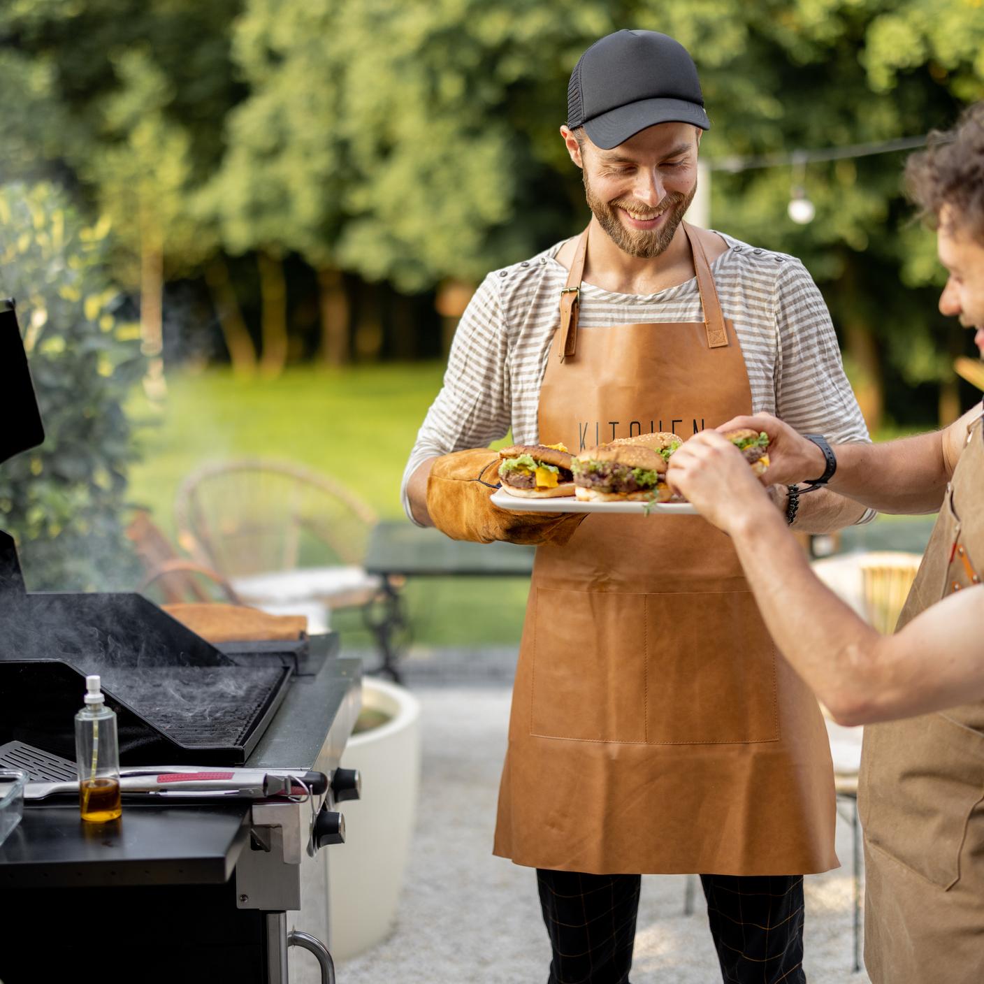 Two male cooking on a gas BBQ in Australia