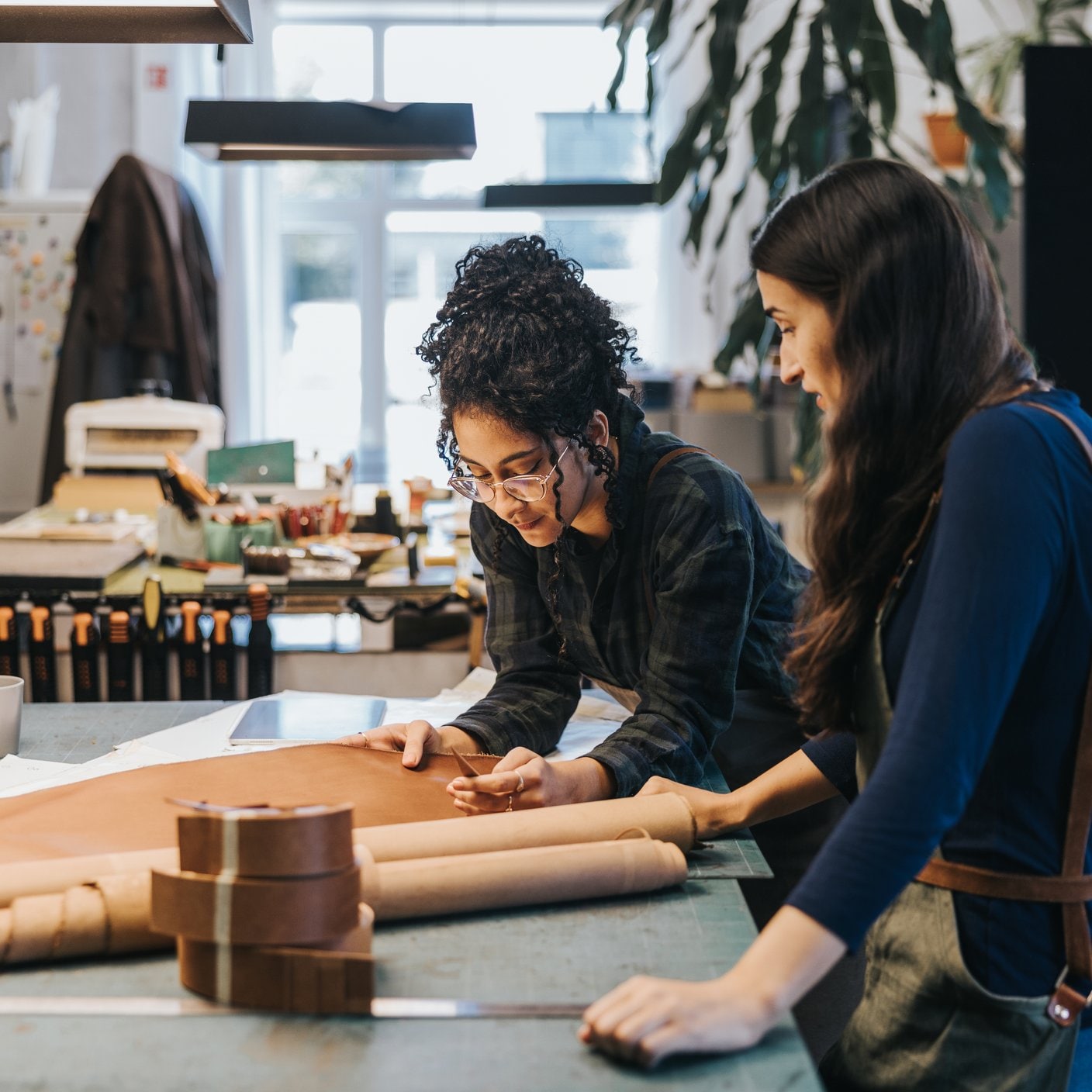 Photo series of zero waste leathercraft workshop with Japanese and Latin designers and Artisans working together in bright creative studio.