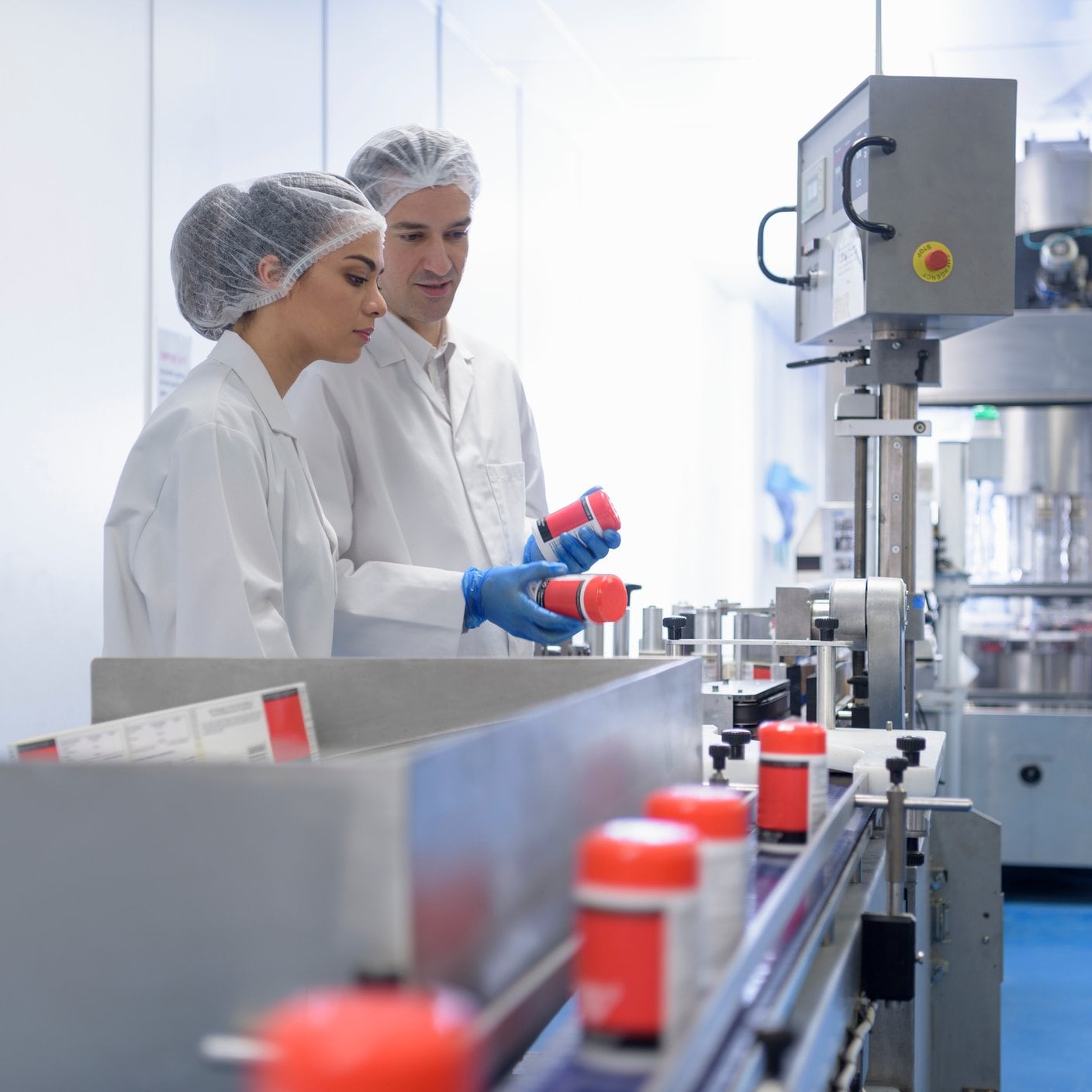 Workers on pill packing line in pharmaceutical factory.