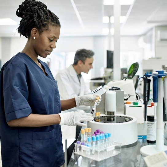 Pathology technician in blue scrubs in laboratory test