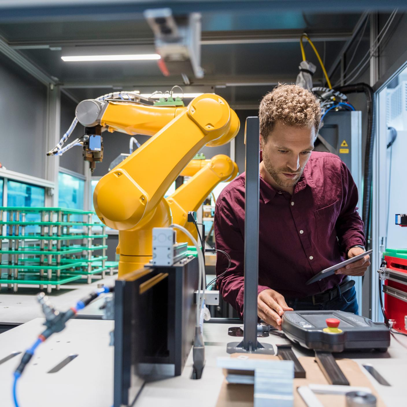 Businessman checking industrial robot in high tech company.