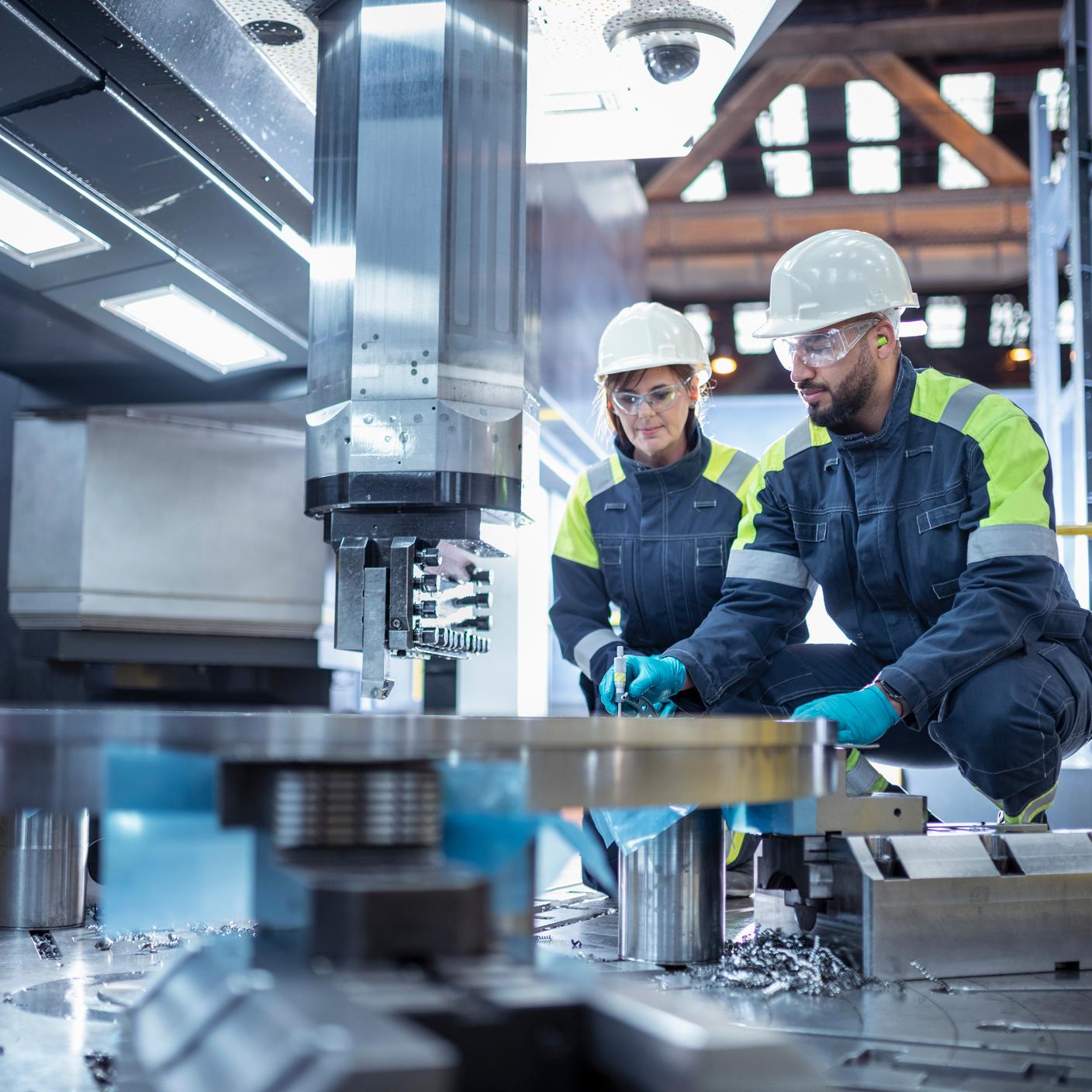 Male and female specialist lathe operators in steelworks