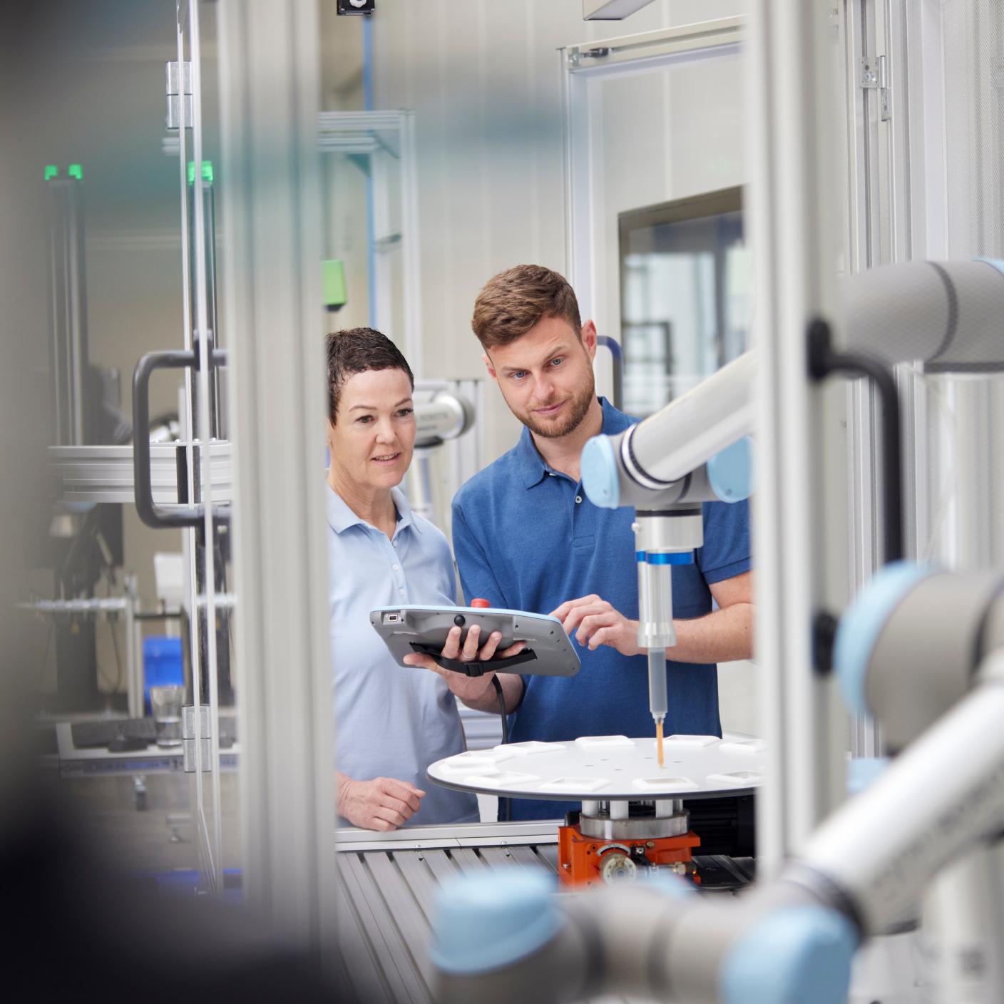 Technicians analyzing robotic machine in industry.