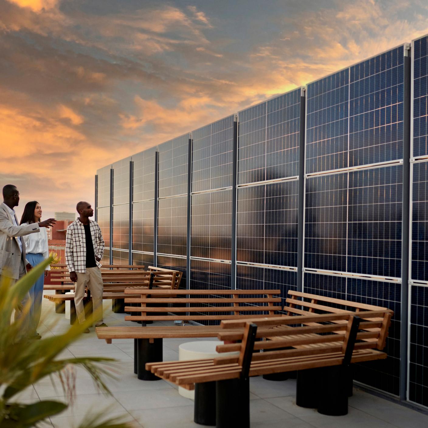 Real estate agent and couple standing on rooftop of environmentally aware office building