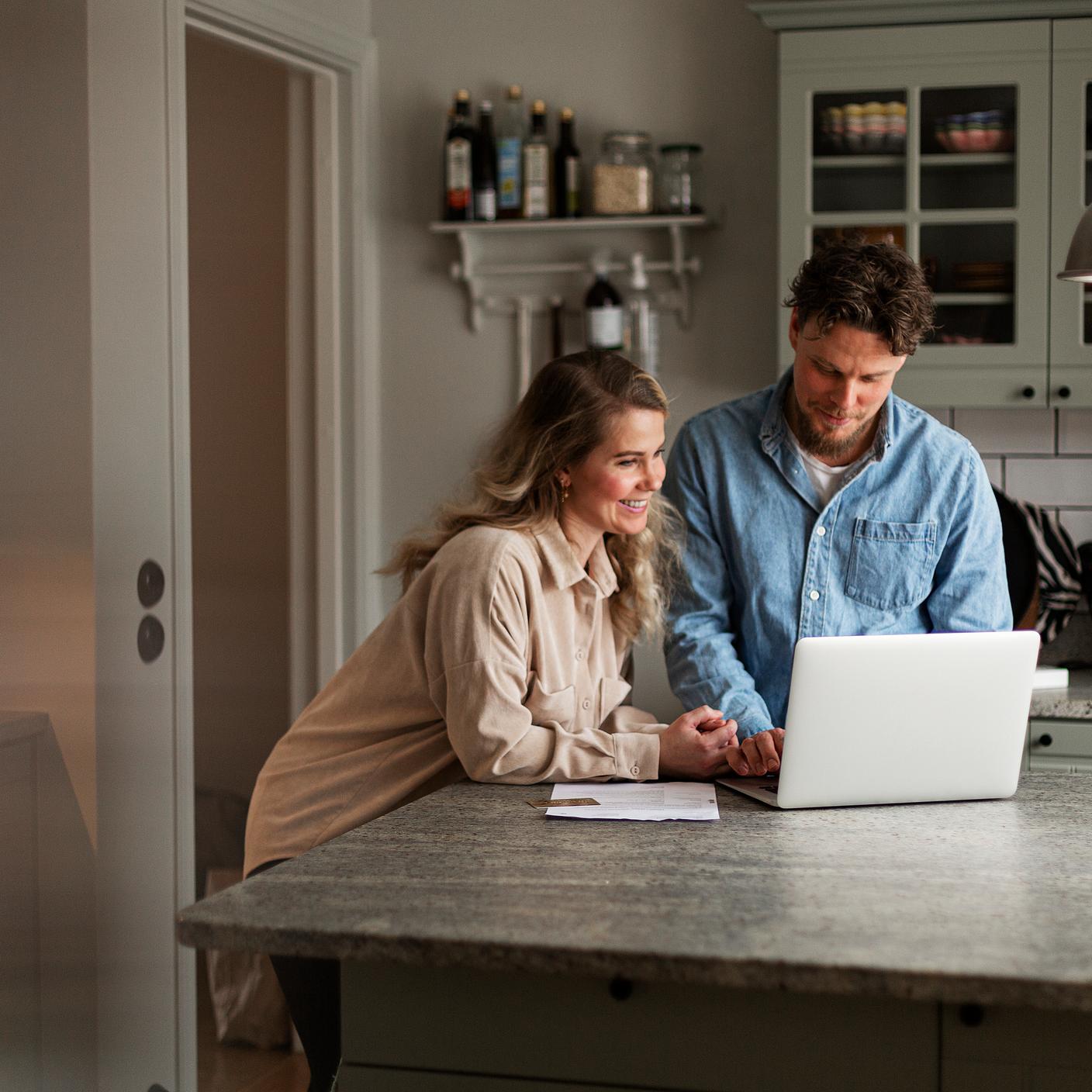 Couple consulting their laptop in their kitchen
