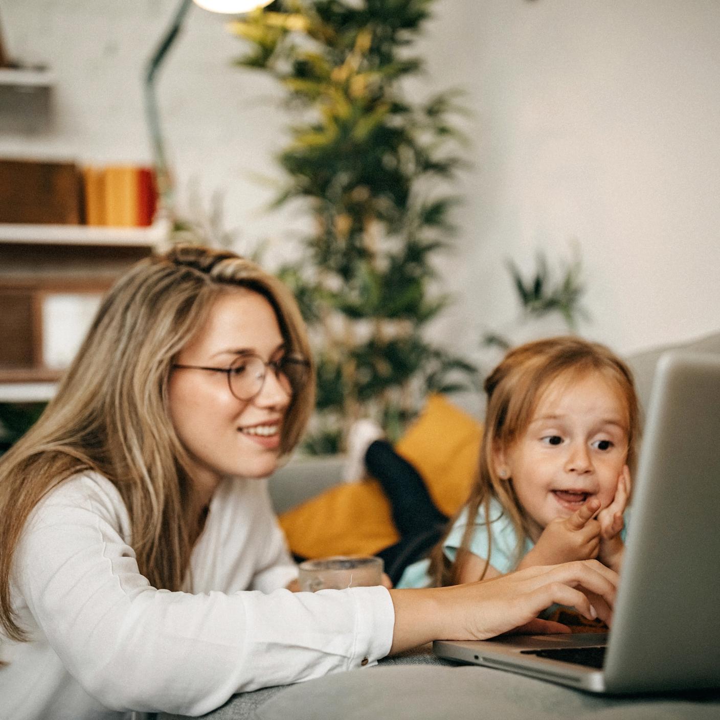 Mother and daughter using laptop together.