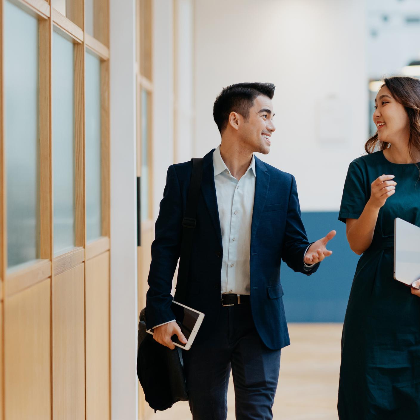 Coworkers discussing business strategy while walking in the corridor