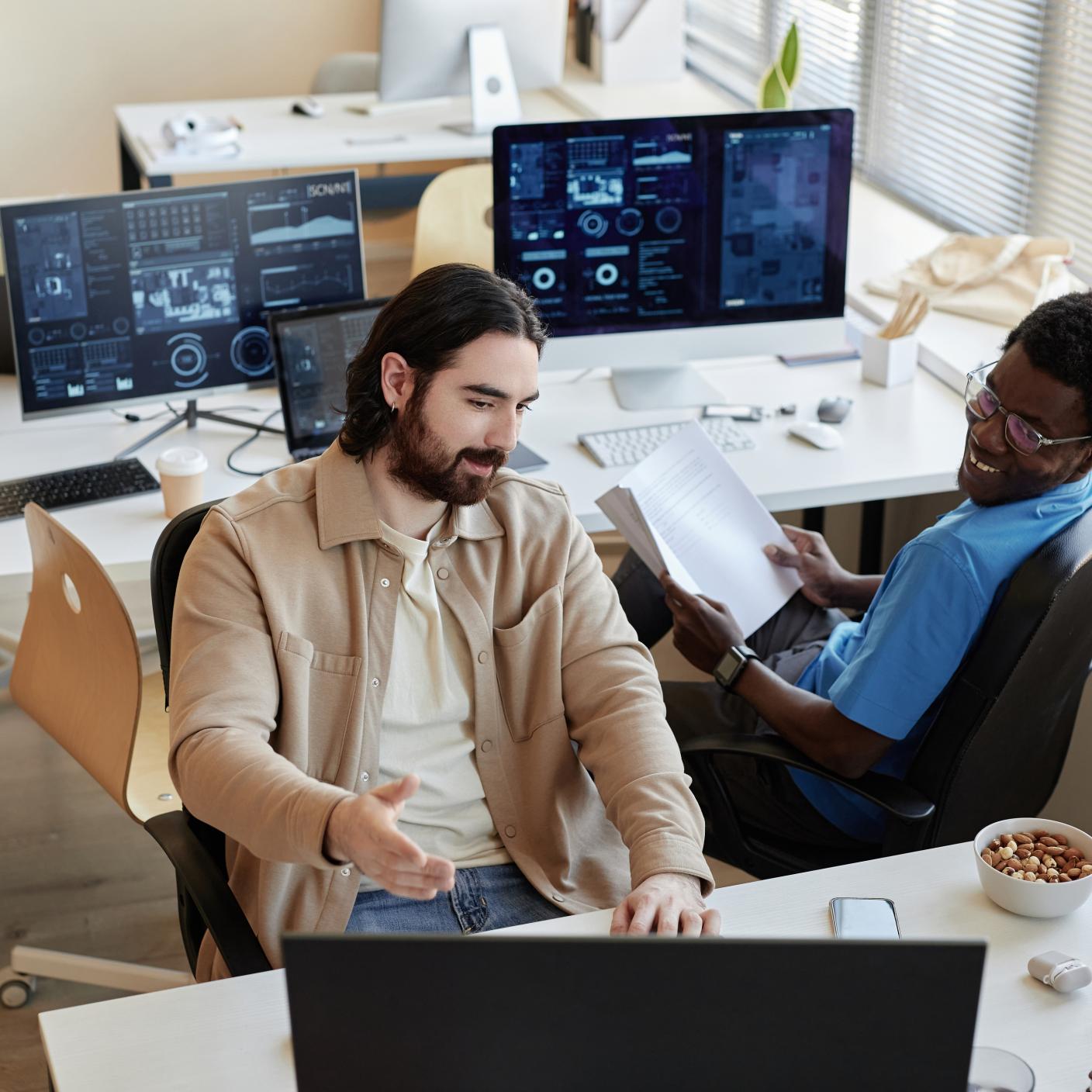 Young businessman showing data on computer screen to smiling.
