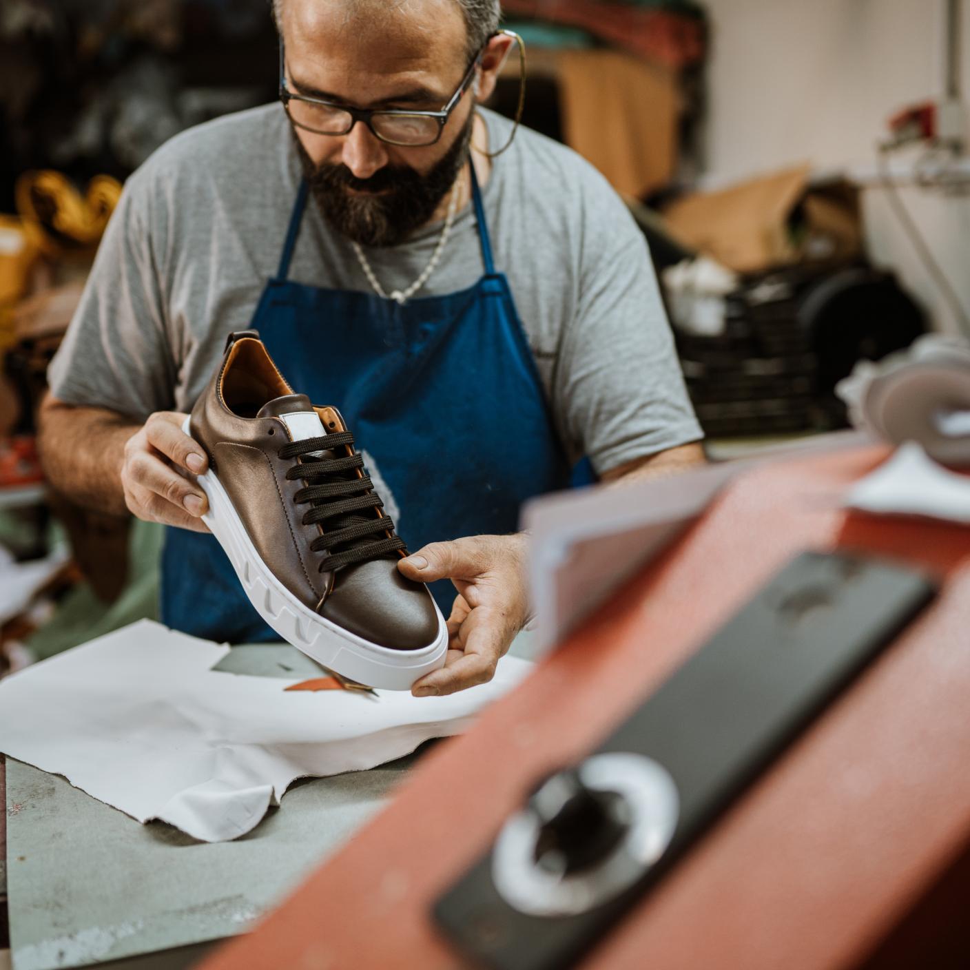 Cobbler admiring to his product.
