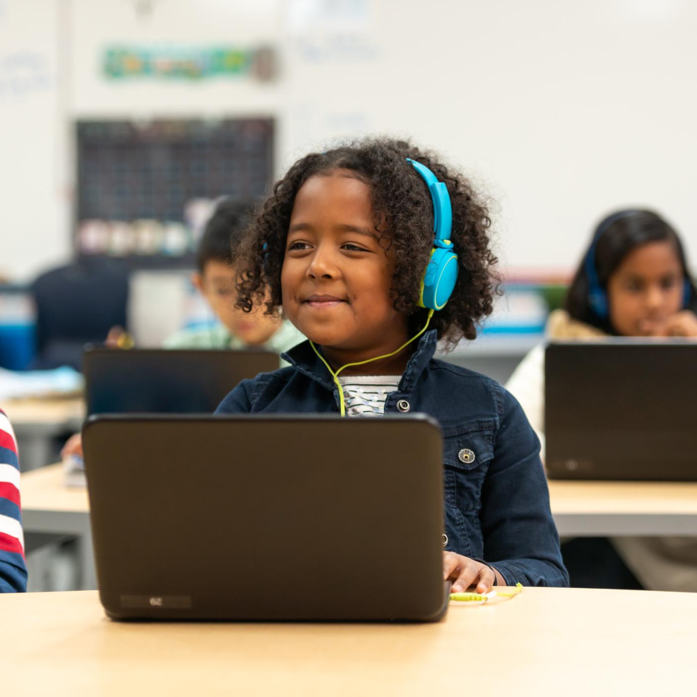 A girl sits at a computer while learning about some interesting facts. 