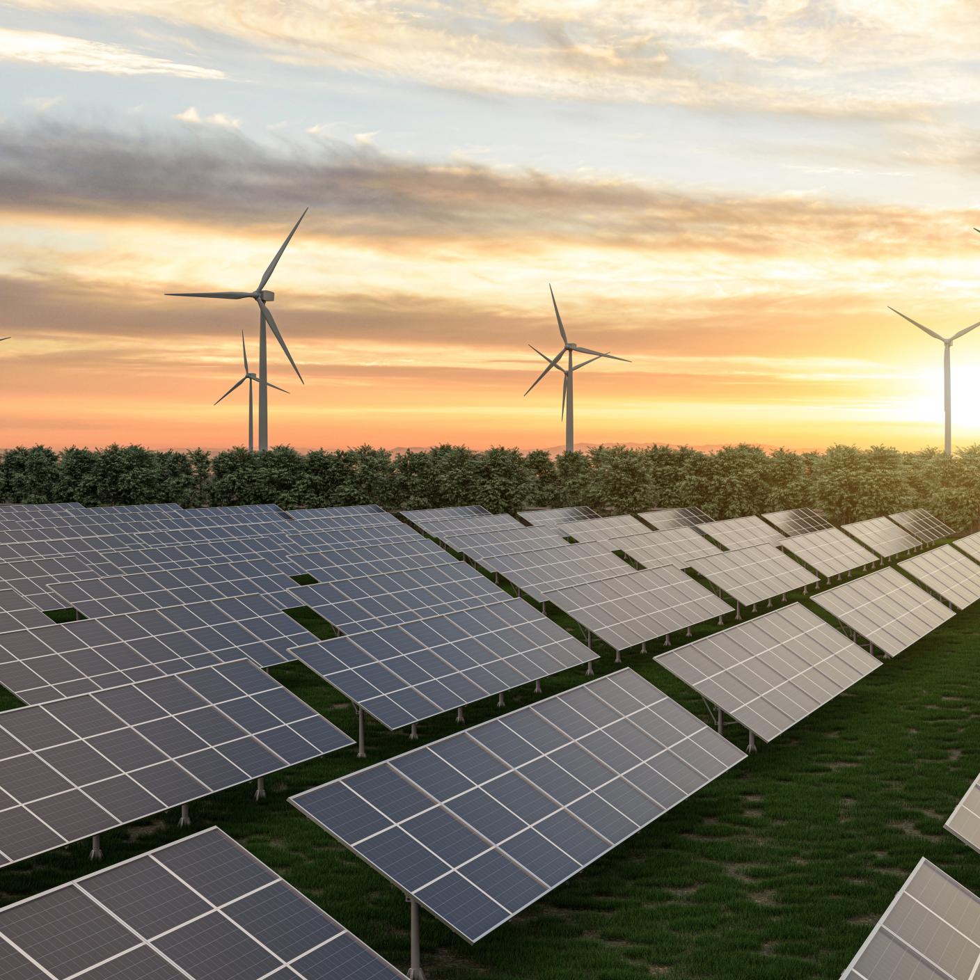 Multiple windmills in operation in the sunset.
