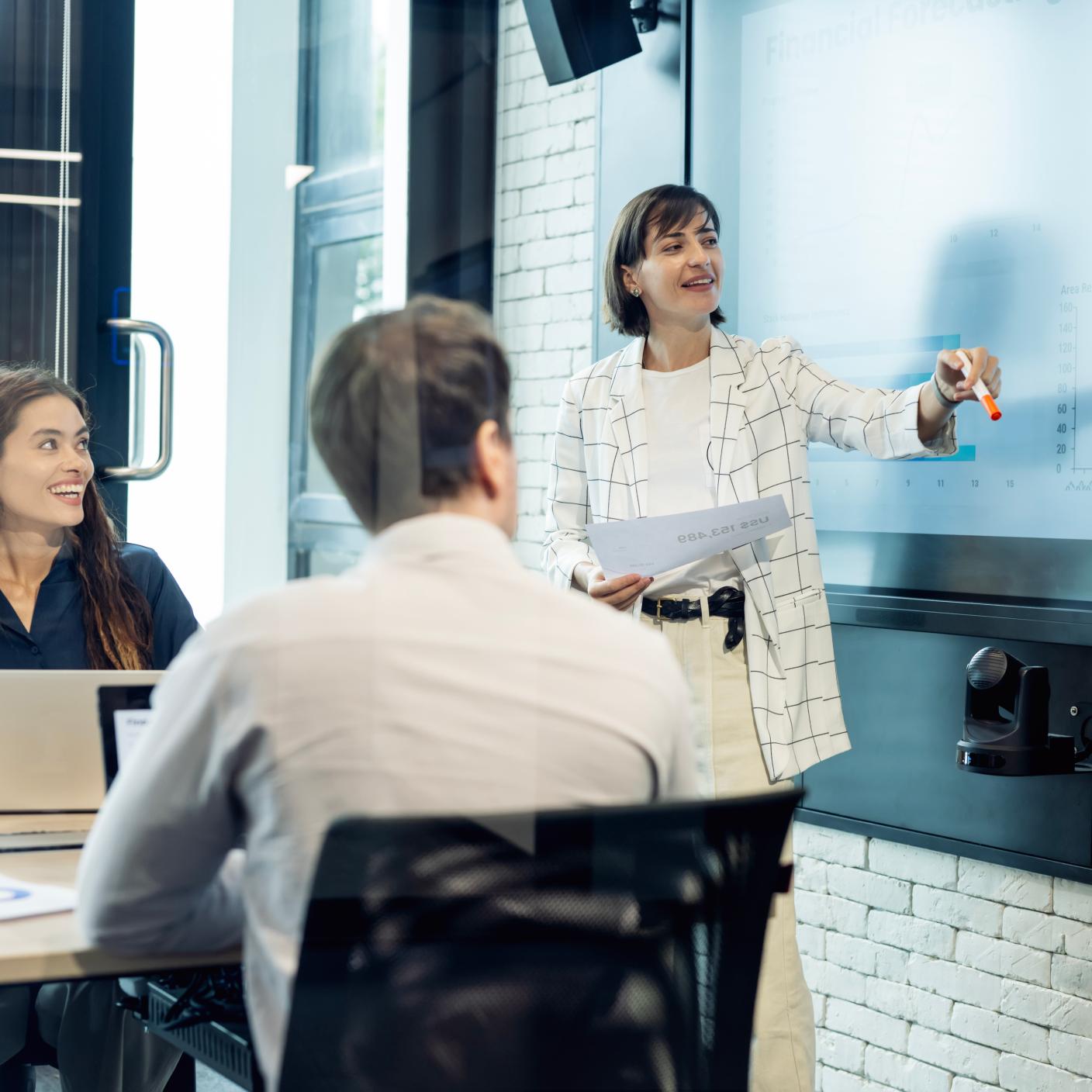 A diverse business development team plans a marketing strategy using customer insights from digital displays to launch a campaign.