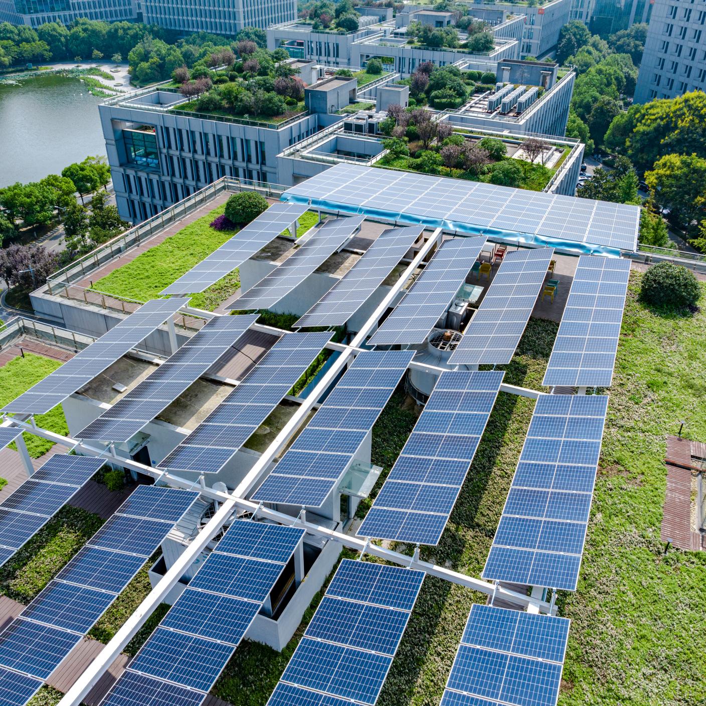 Aerial photography of a green city with many green plants and solar panels on the roof