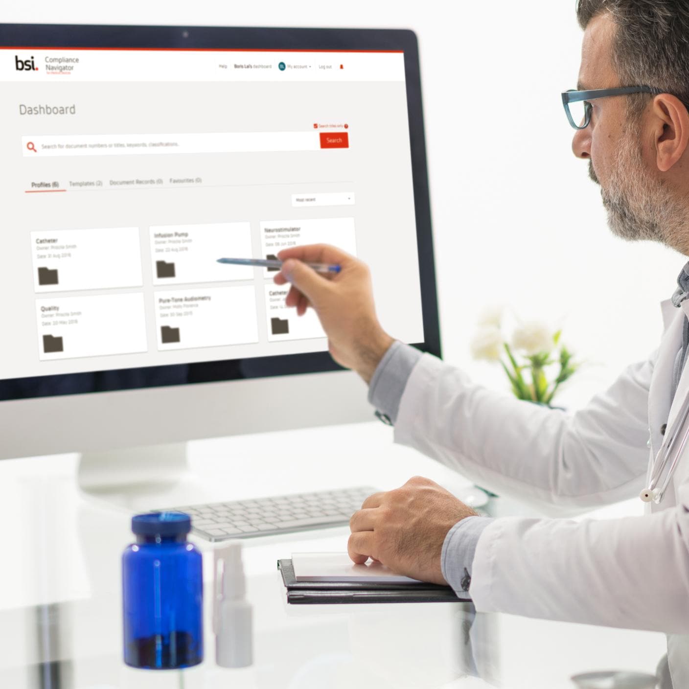 Medical research scientist dropping a sample onto a slide while her colleague examines it under a microscope in a modern laboratory.