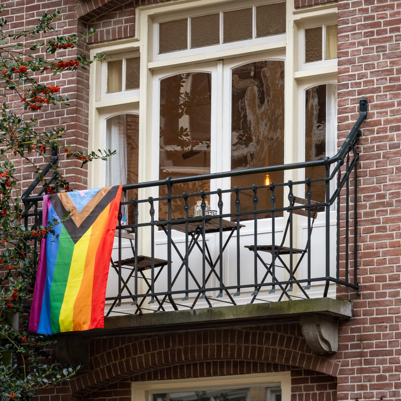 Progress Pride flag on a balcony of a building