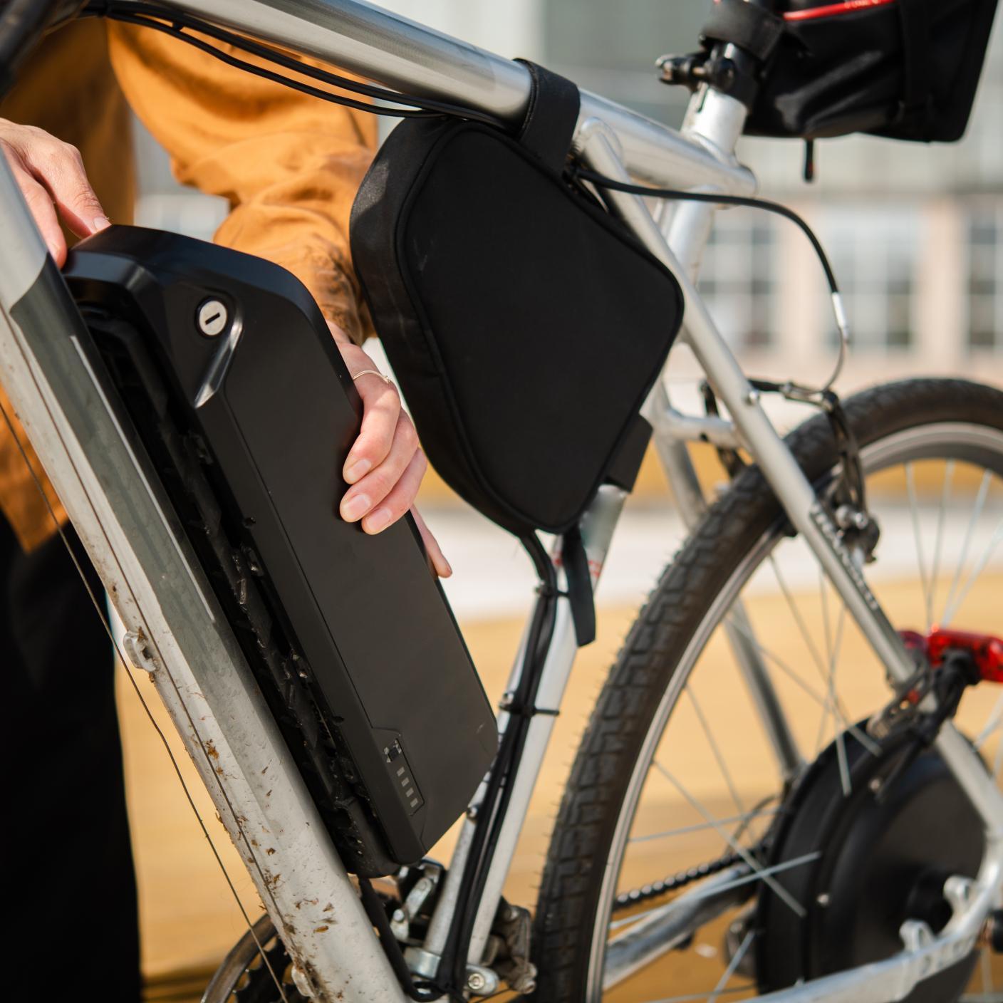 Woman changing an electric bike battery.