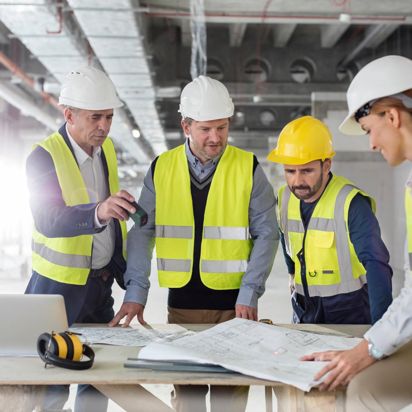 Engineers reviewing blueprints at construction site