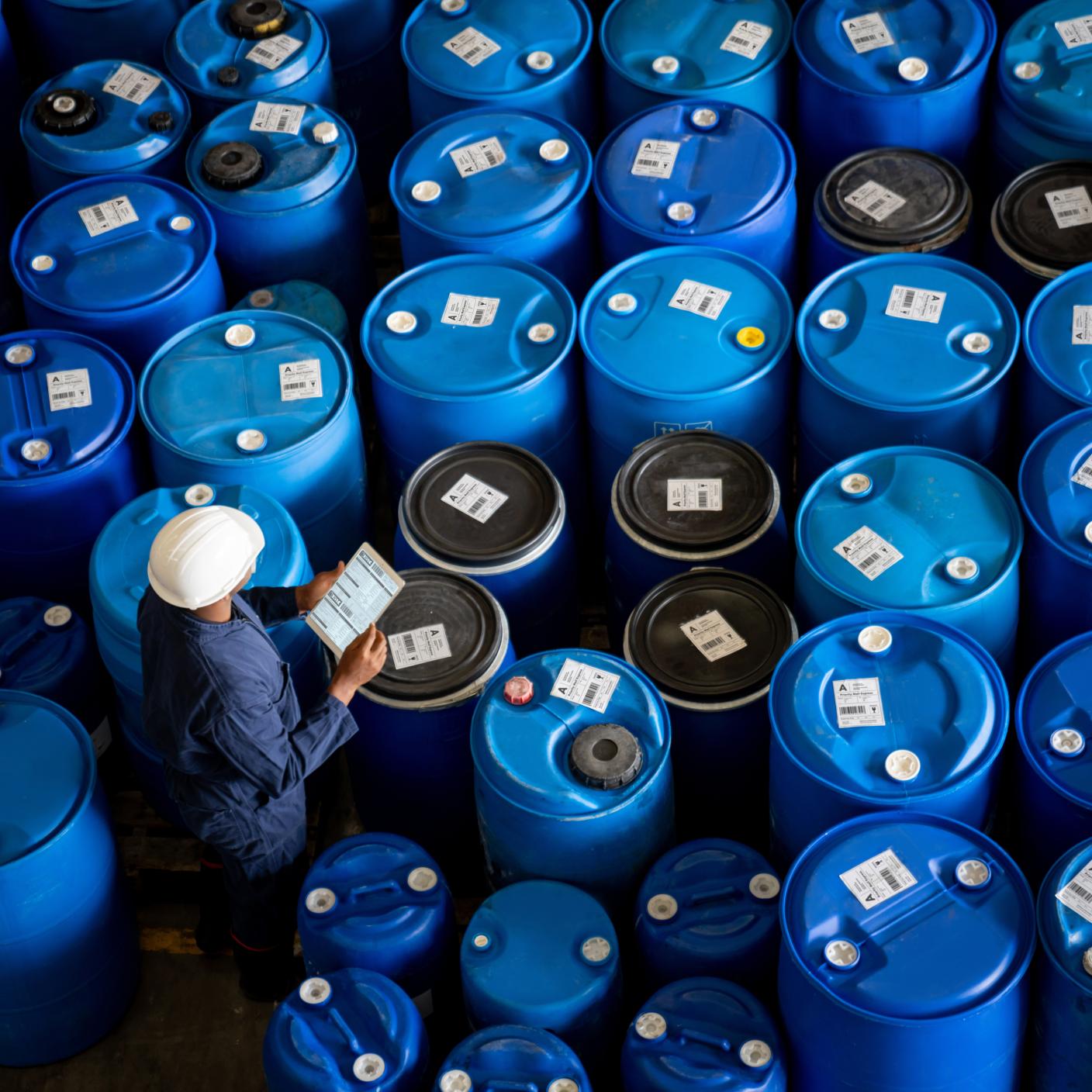 Blue-collar worker doing an inventory while working at a chemical plant using a tablet computer - manufacturing industry concepts