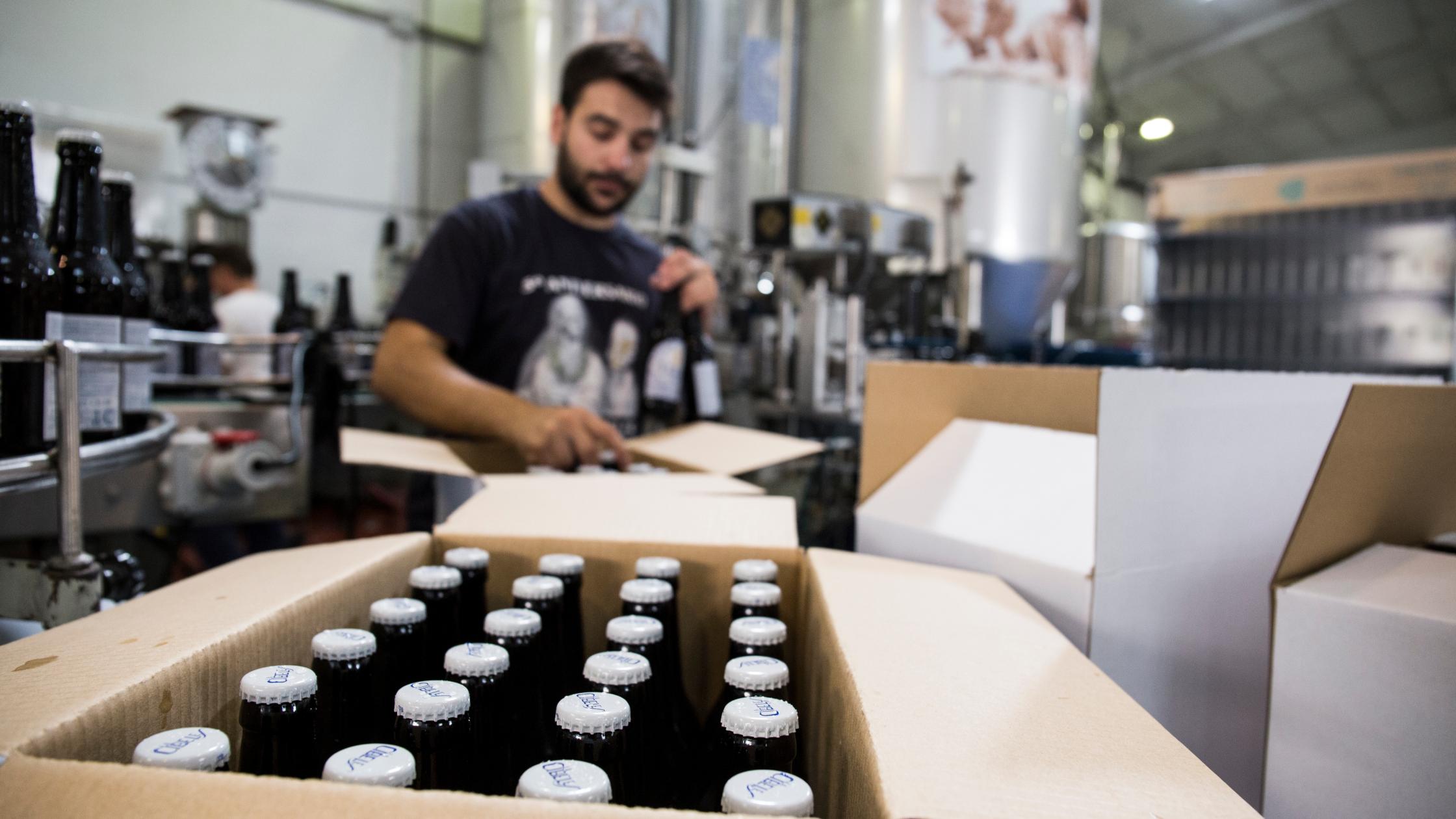 Man in package factory packing bottles.