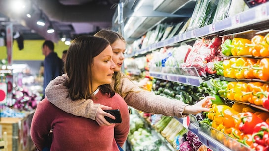 A woman and her little girl buying groceries in a supermarket