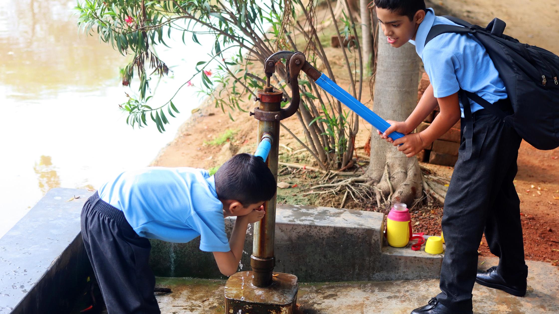 Sicherheit der Ressourcen – Zwei Kinder trinken Wasser