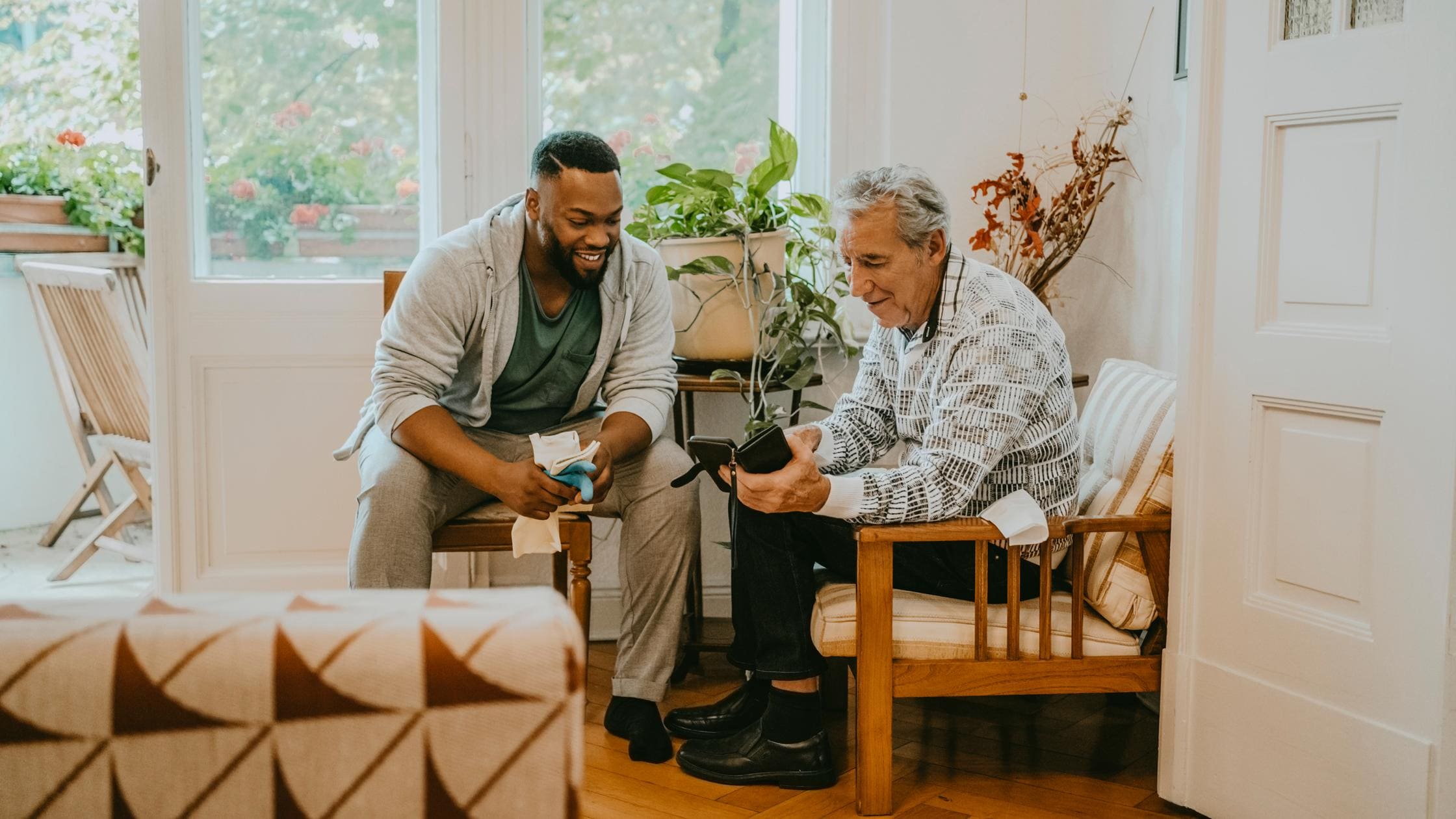 Quality in Healthcare - Senior man sharing smart phone with male healthcare worker