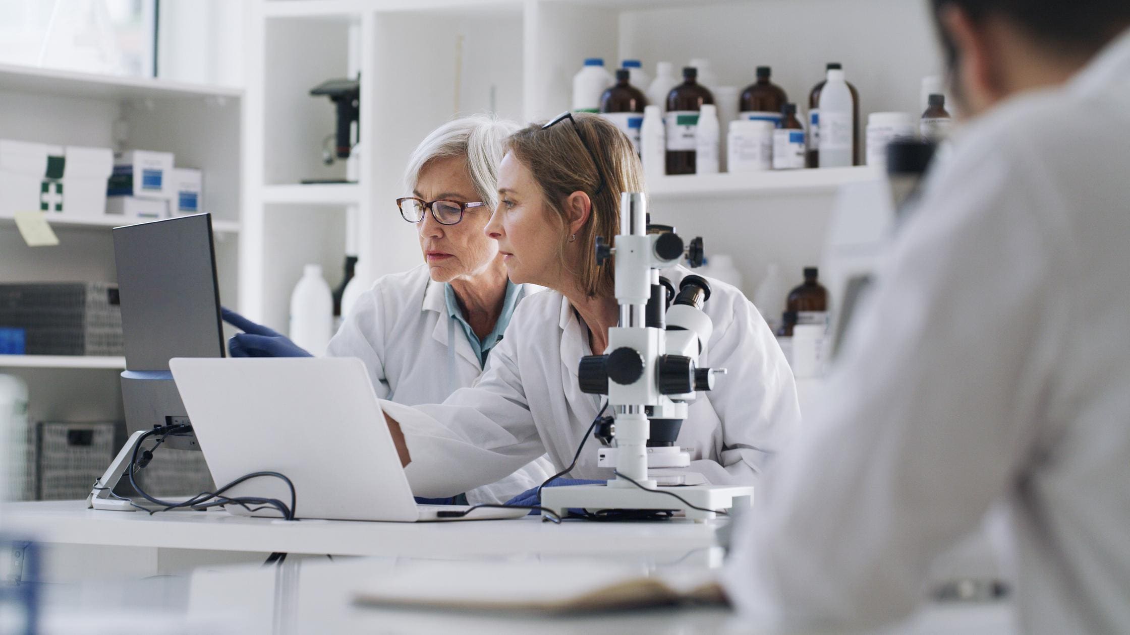 Science, medicine and research, women in laboratory with laptop and equipment.