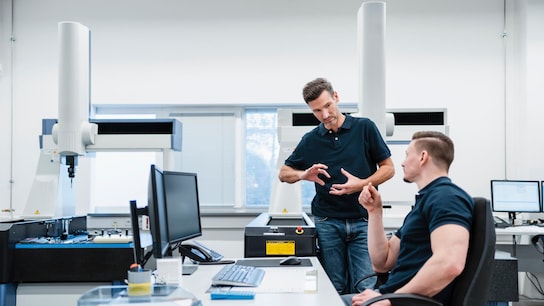 Helping UK manufacturing embrace digitalization - Male engineers at desk discussing in industry office