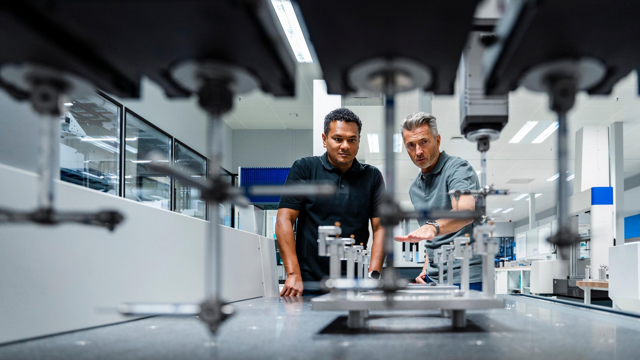 Quality :Engineers discussing over machinery at factory