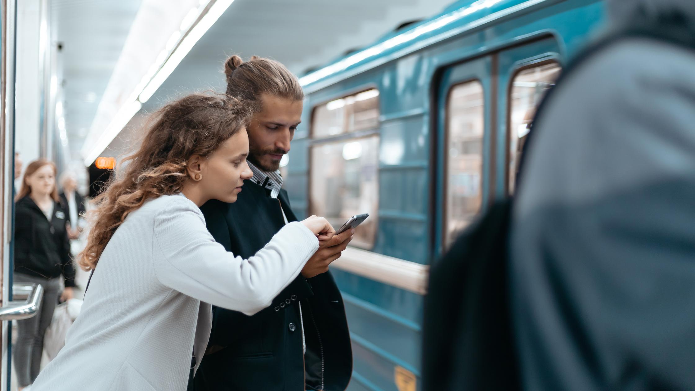 Digital Trust in the Built Environment - Young couple with a smartphone on the subway platform