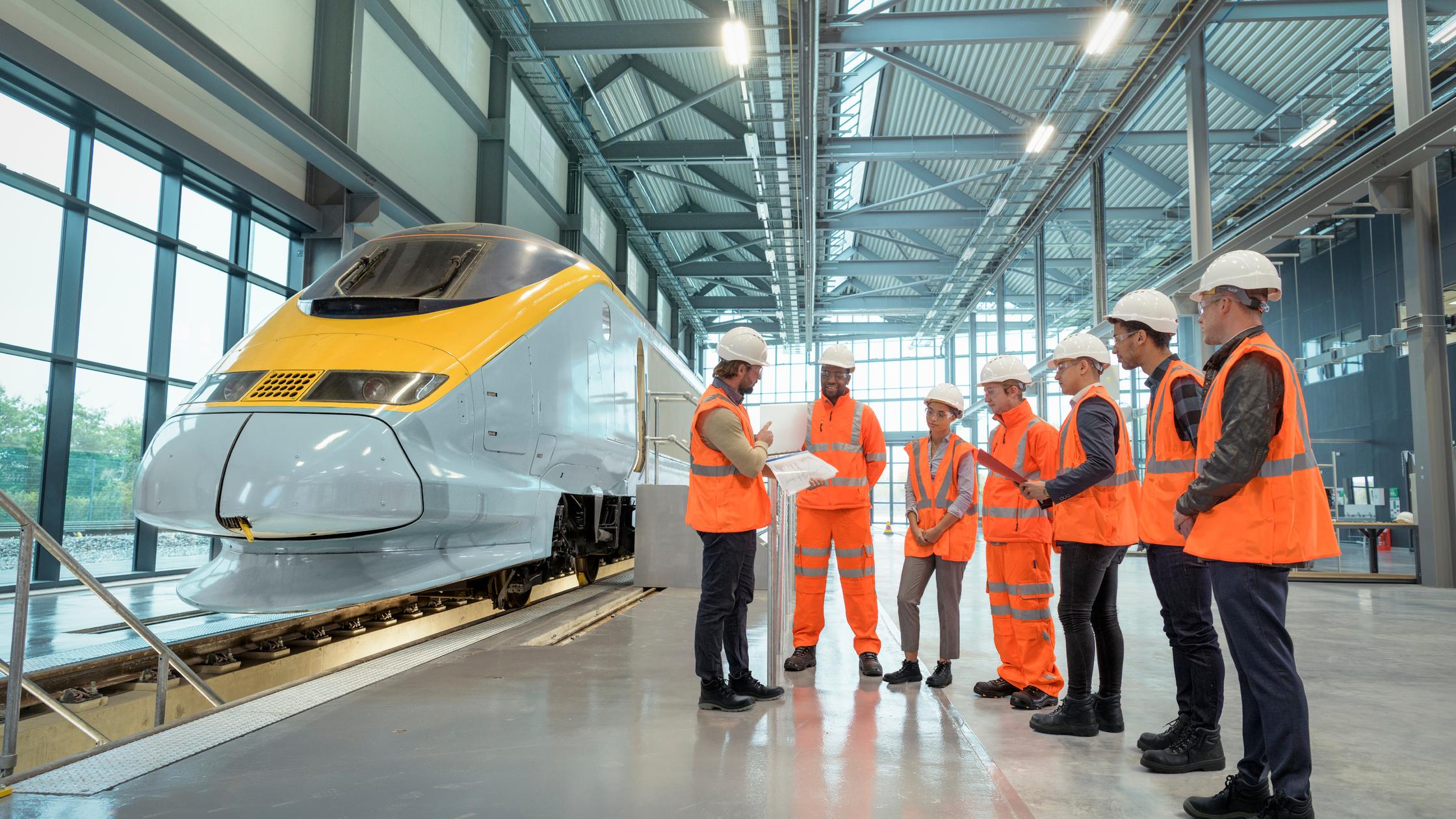 Innovation in Government - Teacher talking to apprentices at railway engineering facility