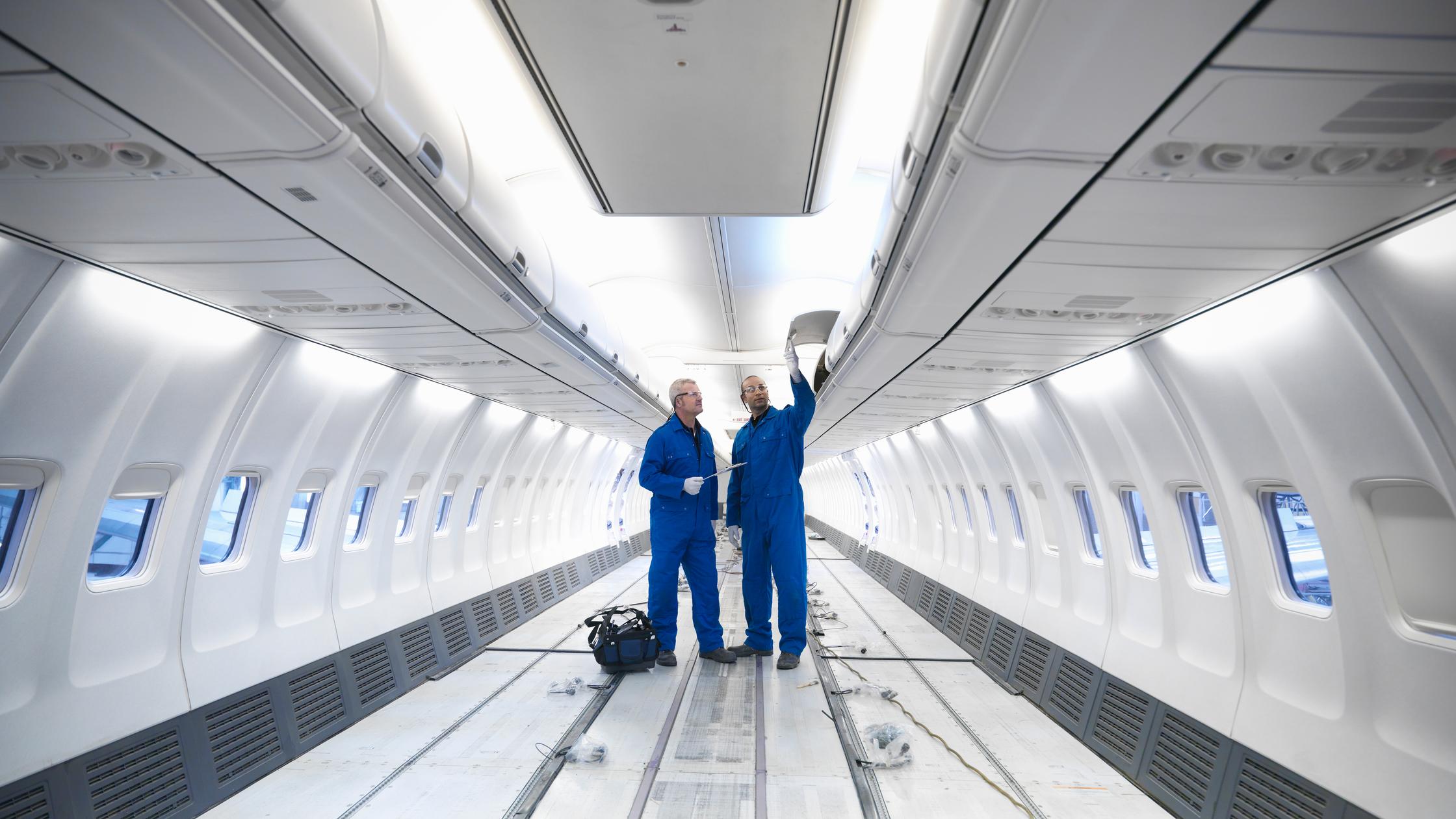 Aircraft engineers working on interior of 737 jet airplane