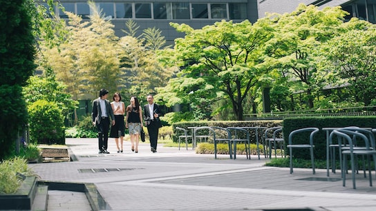 Business people walking through office gardens